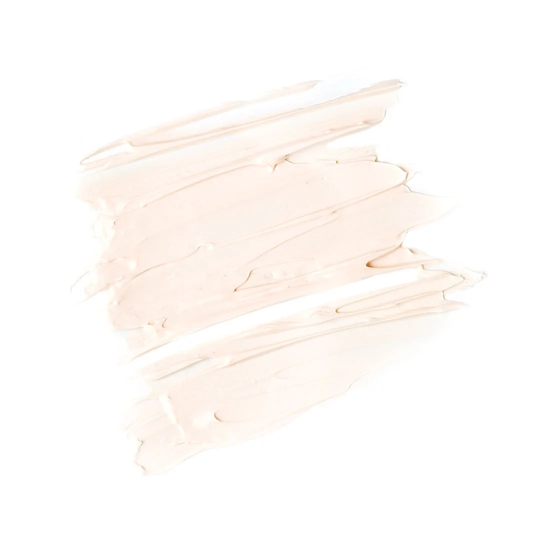 Swatch of light beige or cream-colored cream or lotion spread on a white background.