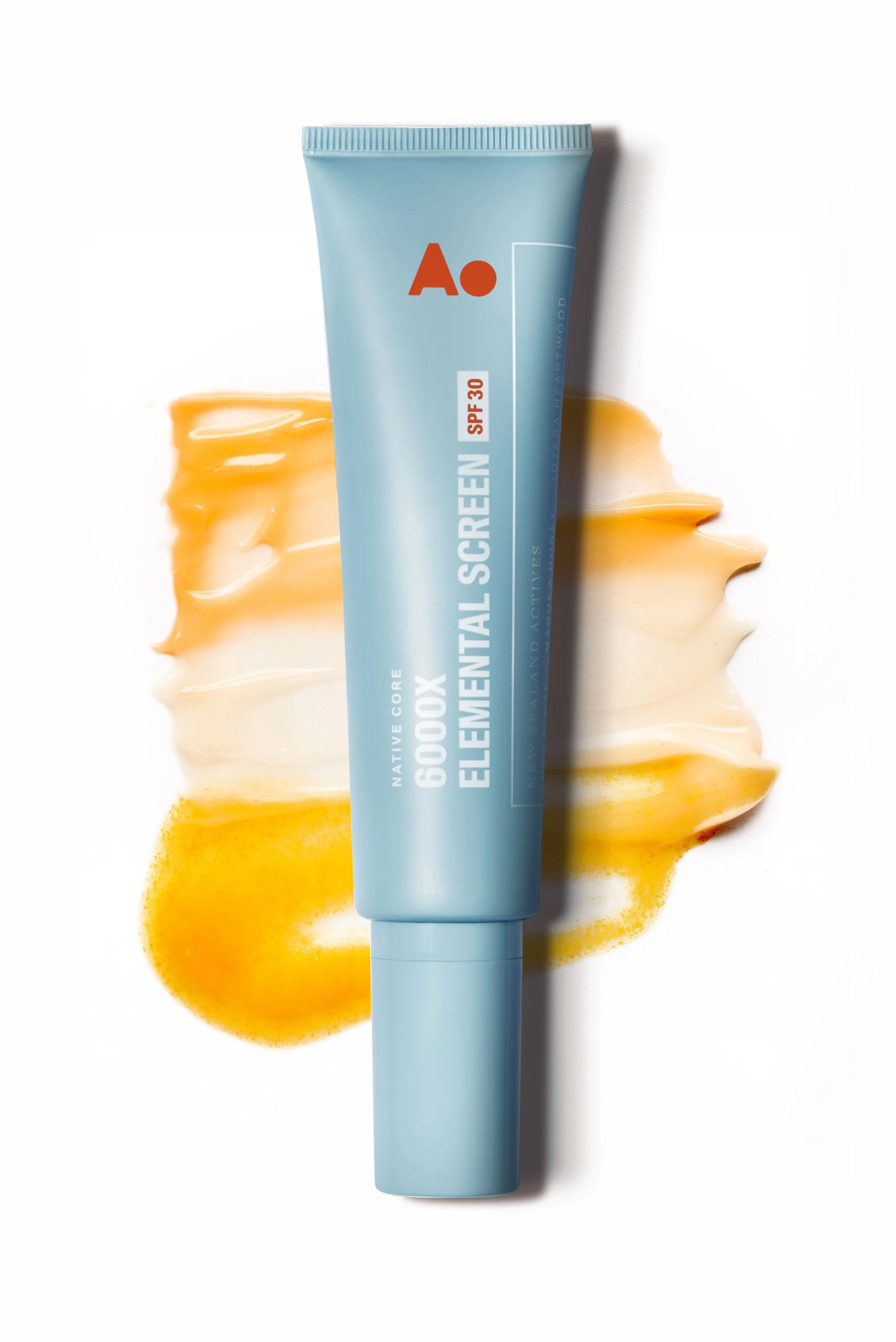 Light blue tube of facial sunscreen with SPF 30 standing on a white surface, with a smear of yellowish-orange sunscreen behind it.