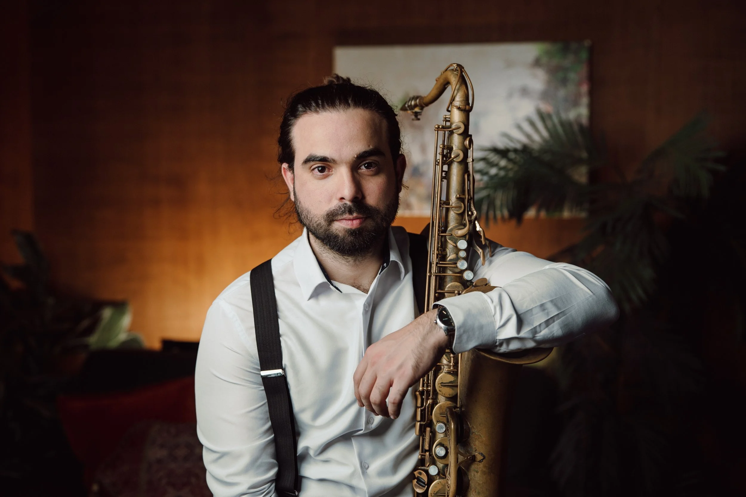 Saxophone teacher holding instrument during music instruction in Houston