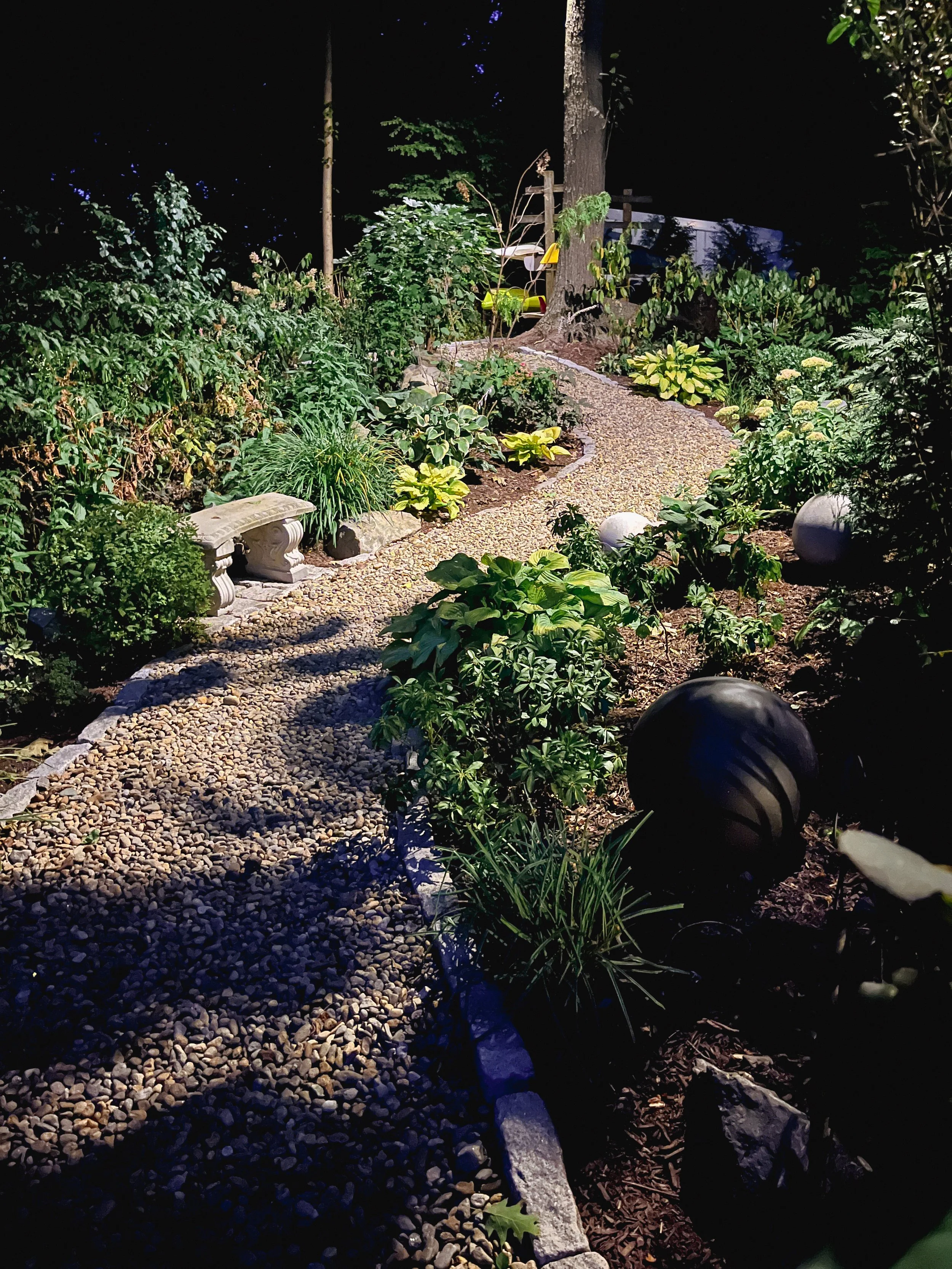 Garden pathway illuminated with professionally designed landscape lighting in Arlington, MA