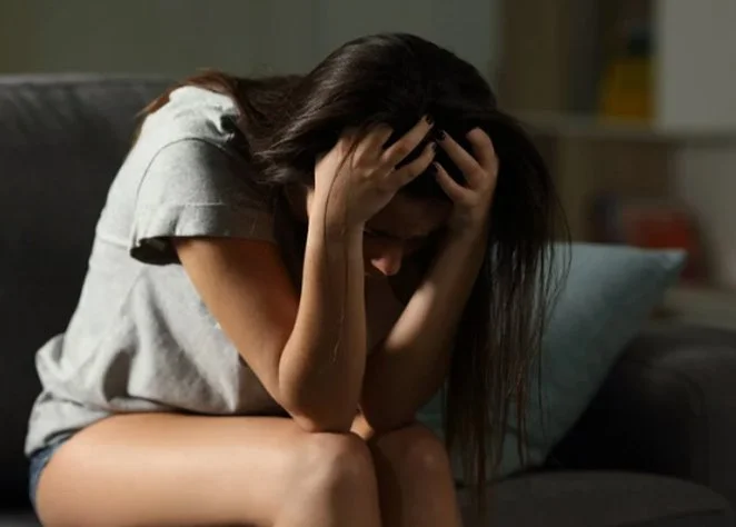 Woman with her face in her hands, ADHD and anxiety in adults