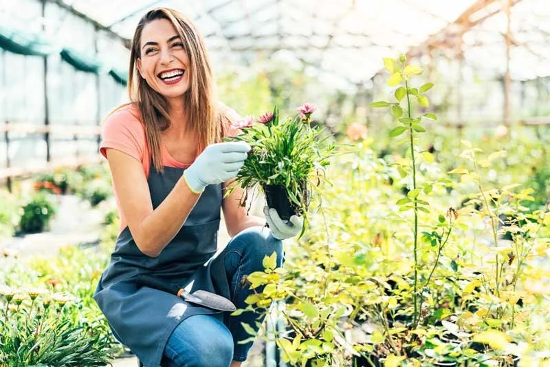 Woman smiling and gardening, mental health during spring