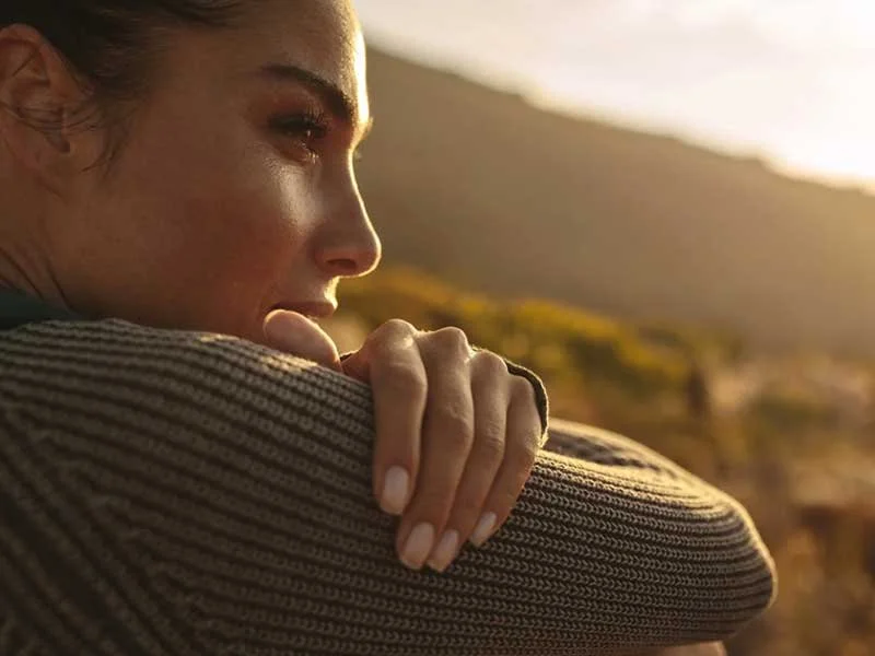 Woman reflecting at sunset on her self worth