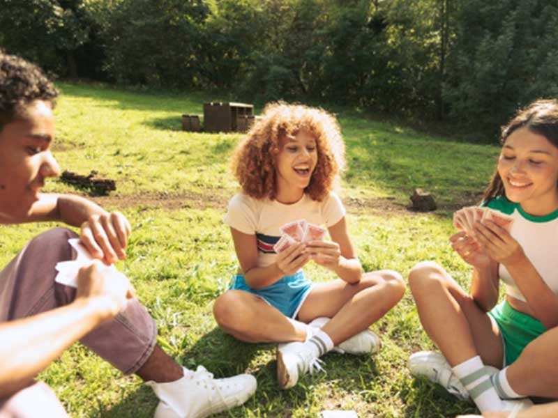 Teens playing cards in the summertime, teen anxiety in summer