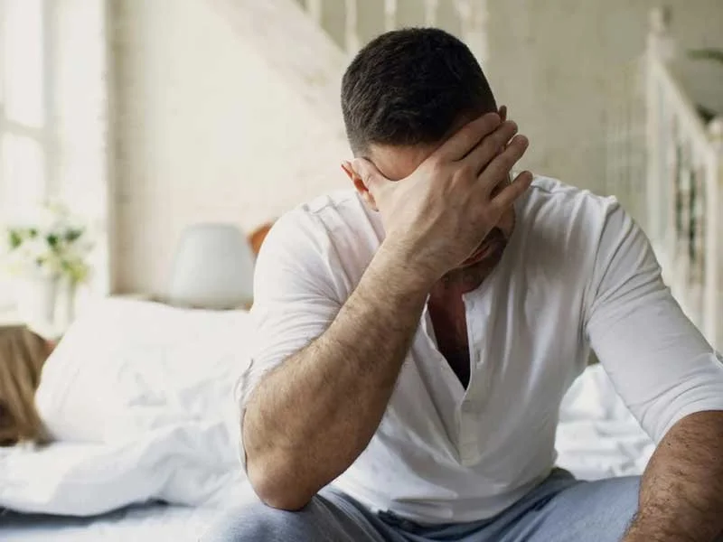 Man with his head in his hands feeling stressed