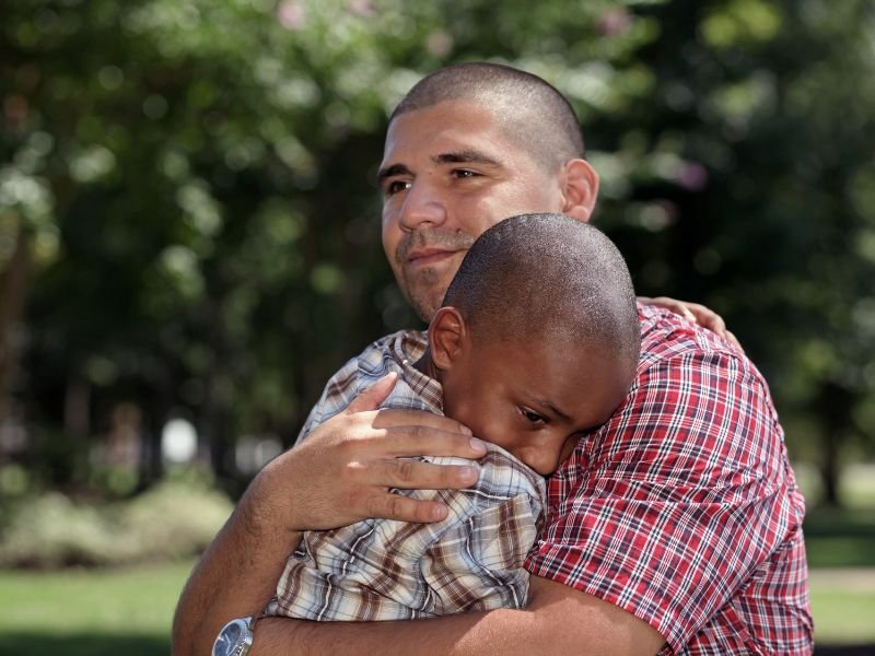 A father hugging his adopted son who is getting therapy for ADHD with CBH