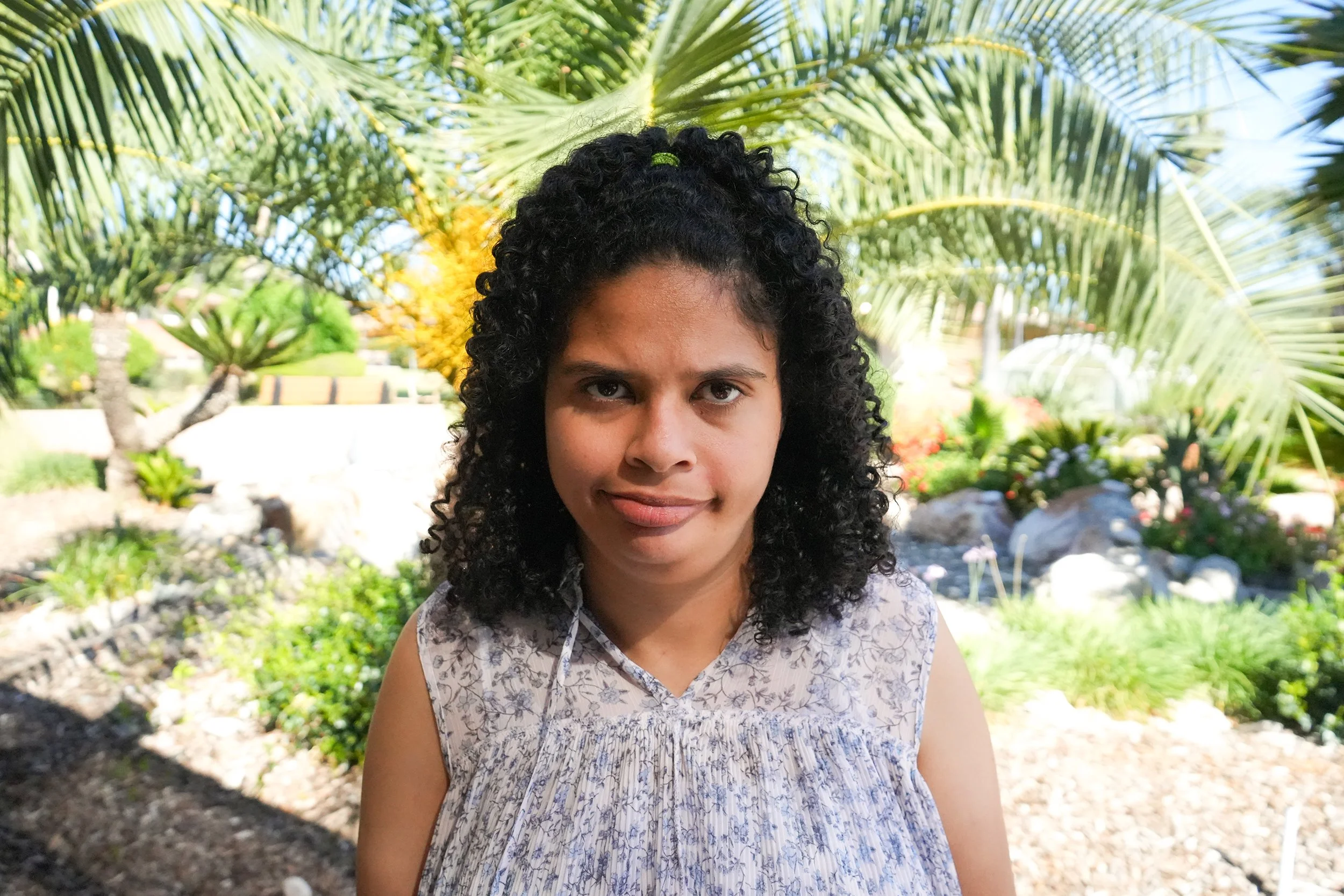 Woman in floral blouse grins for headshot