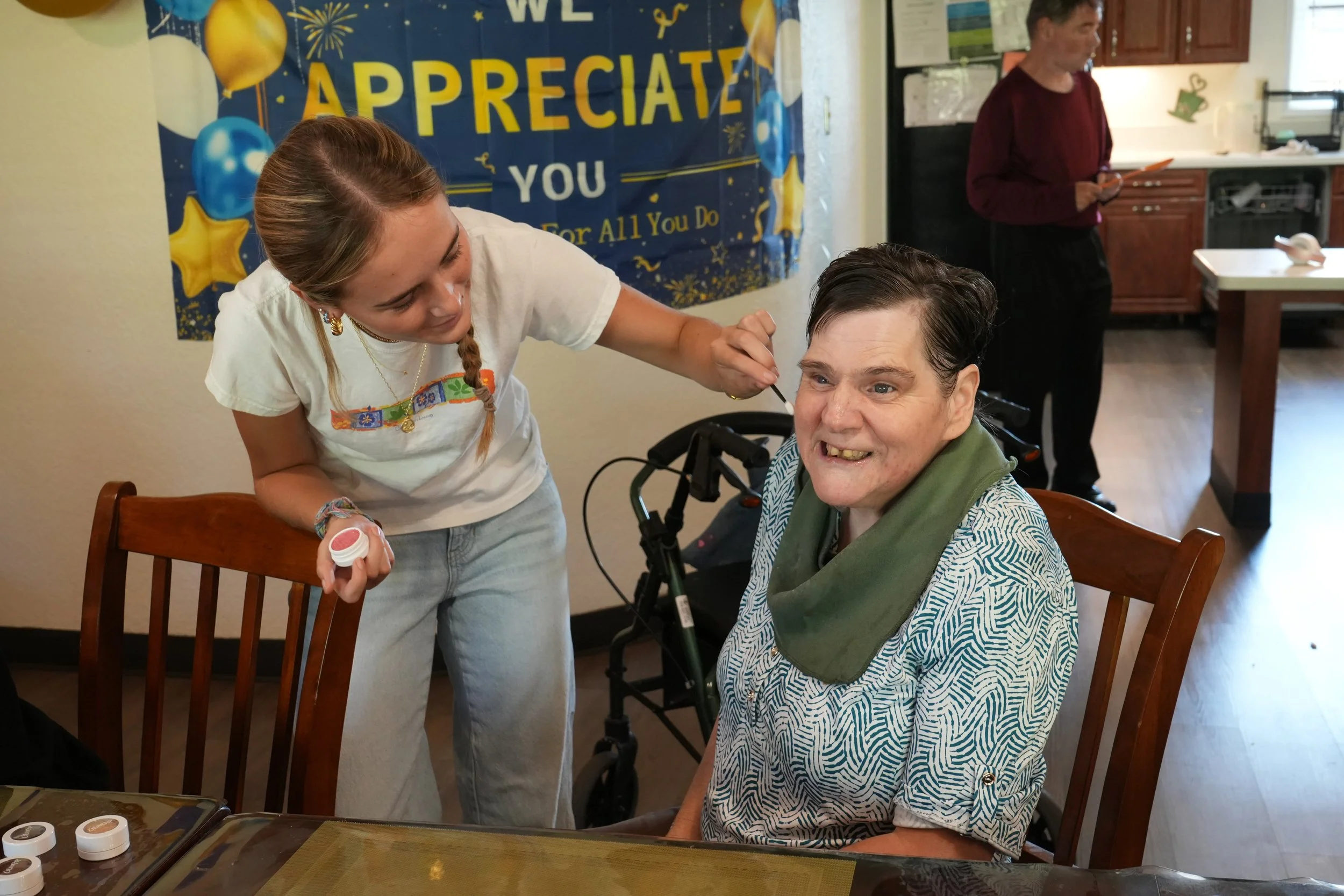Volunteer helping put on makeup