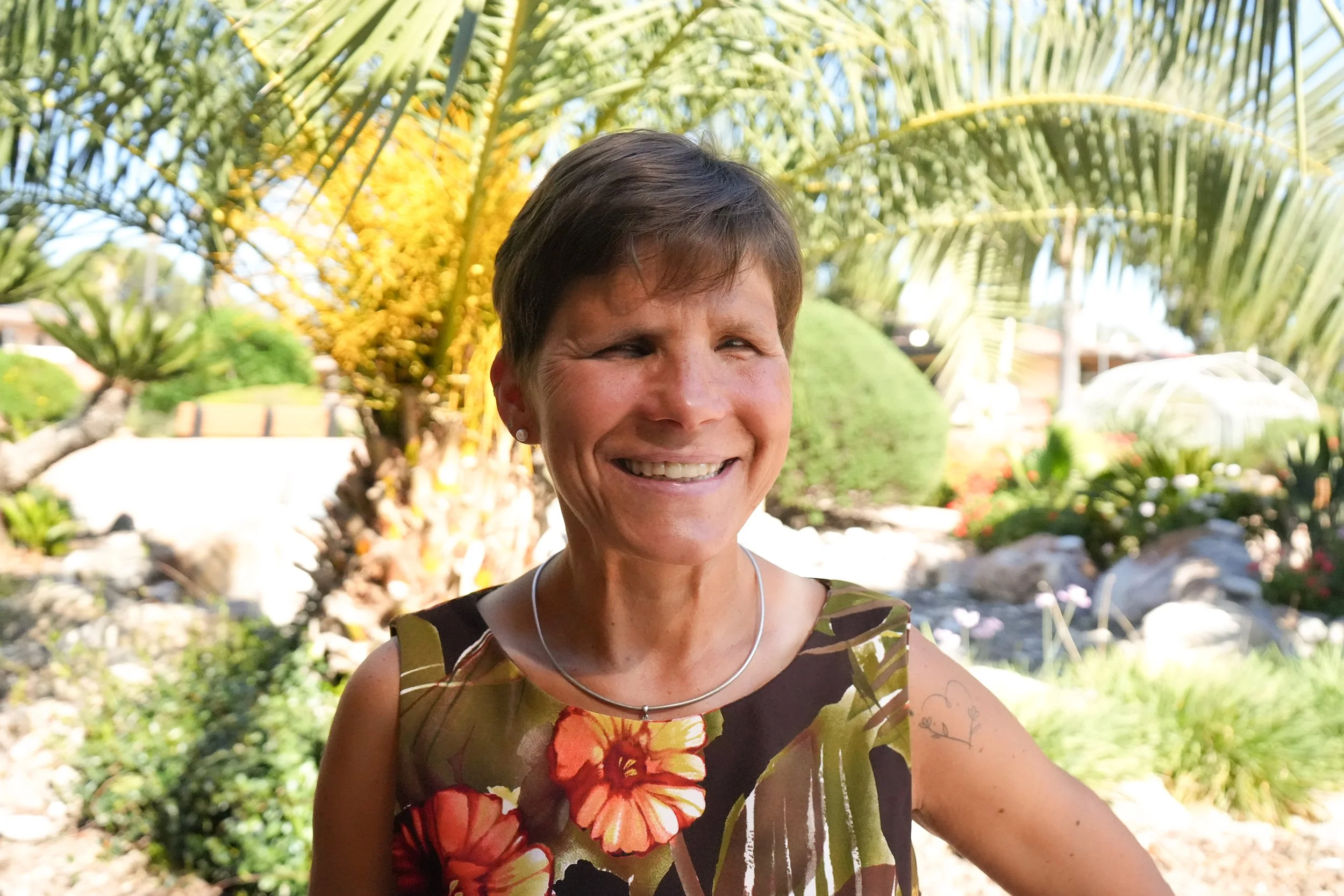 Woman in floral dress smiles for headshot