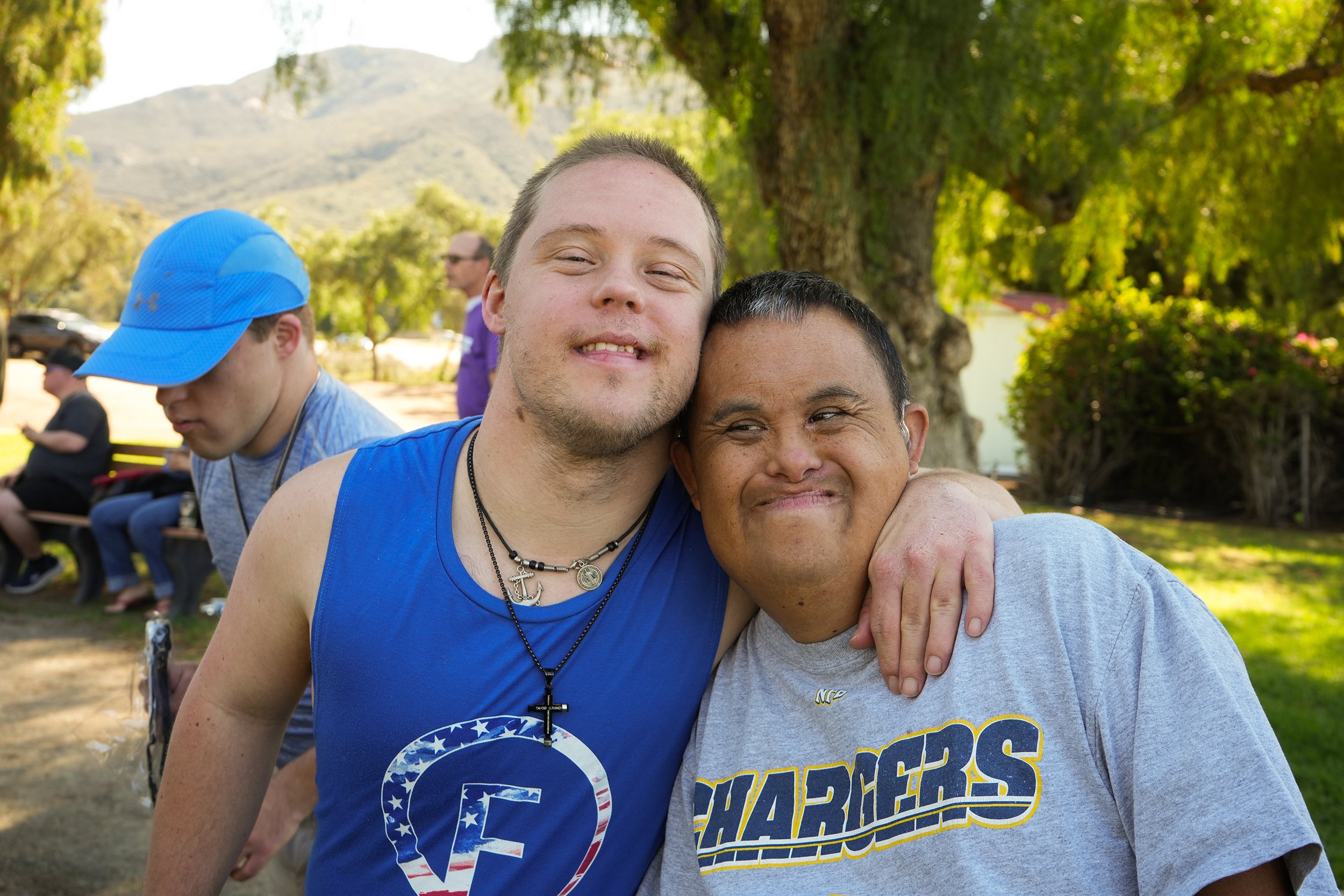 Two adult males with developmental disabilities hugging