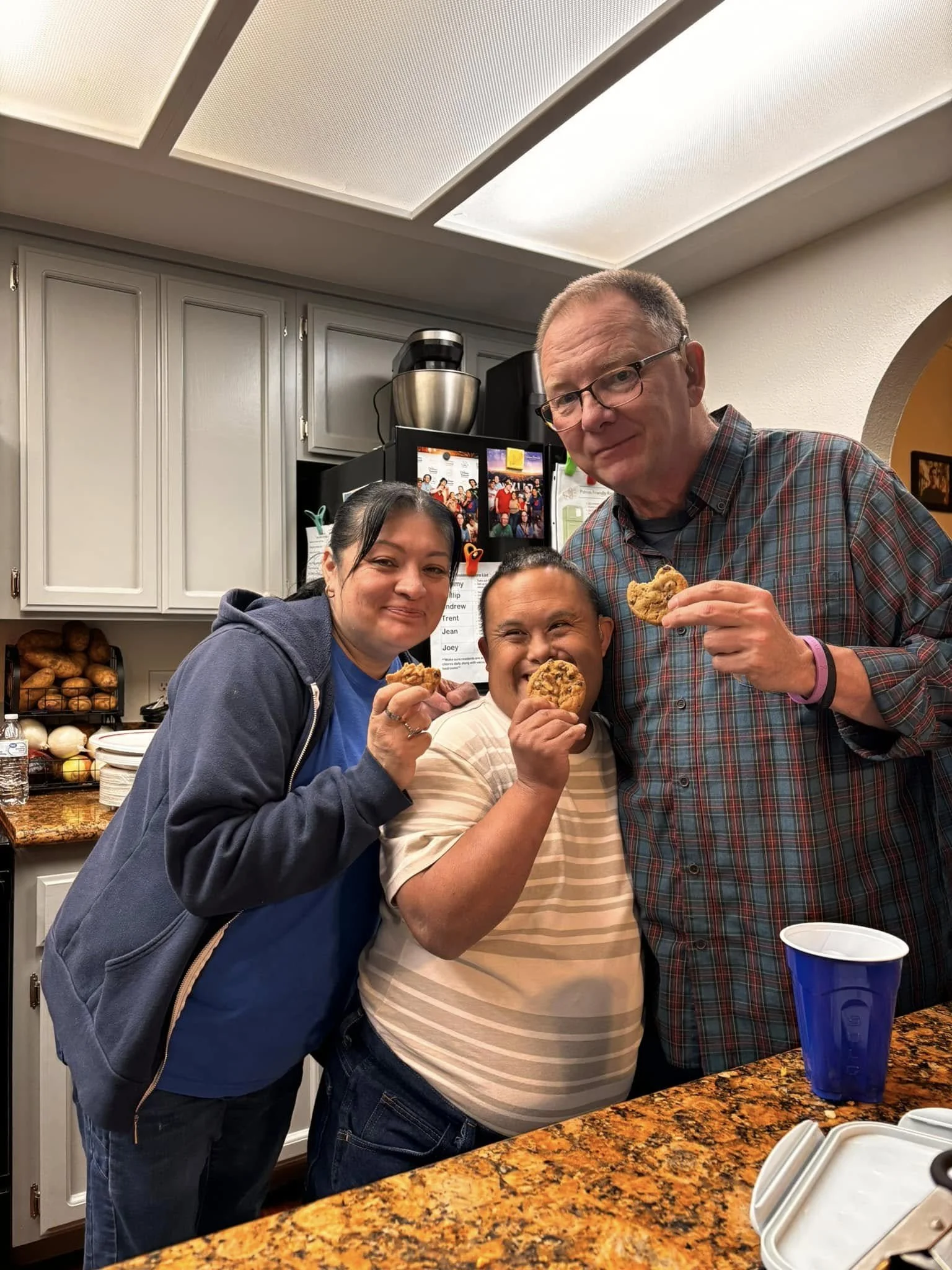 3 adults eating chocolate chip cookies