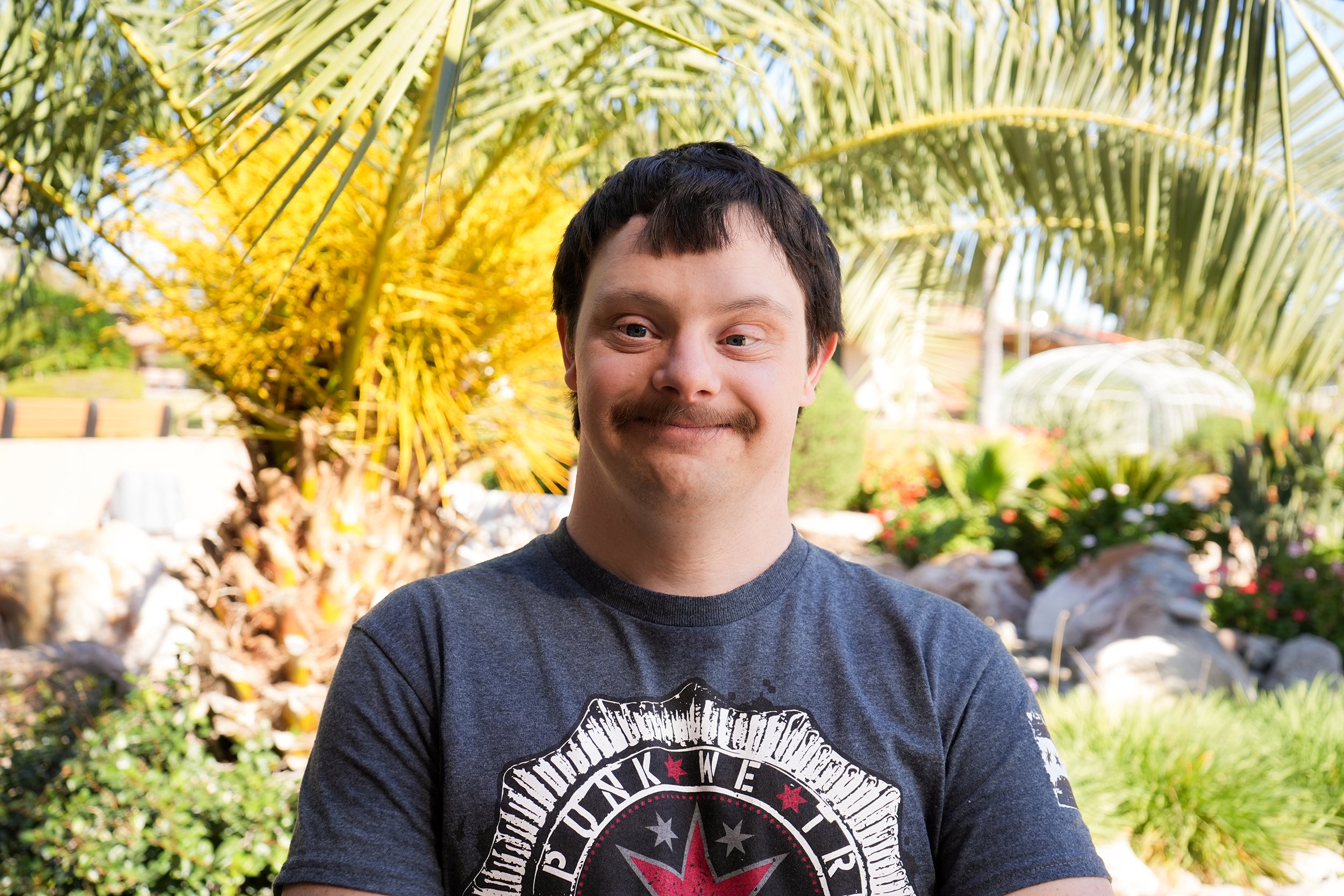 Man in tshirt smiles for headshot