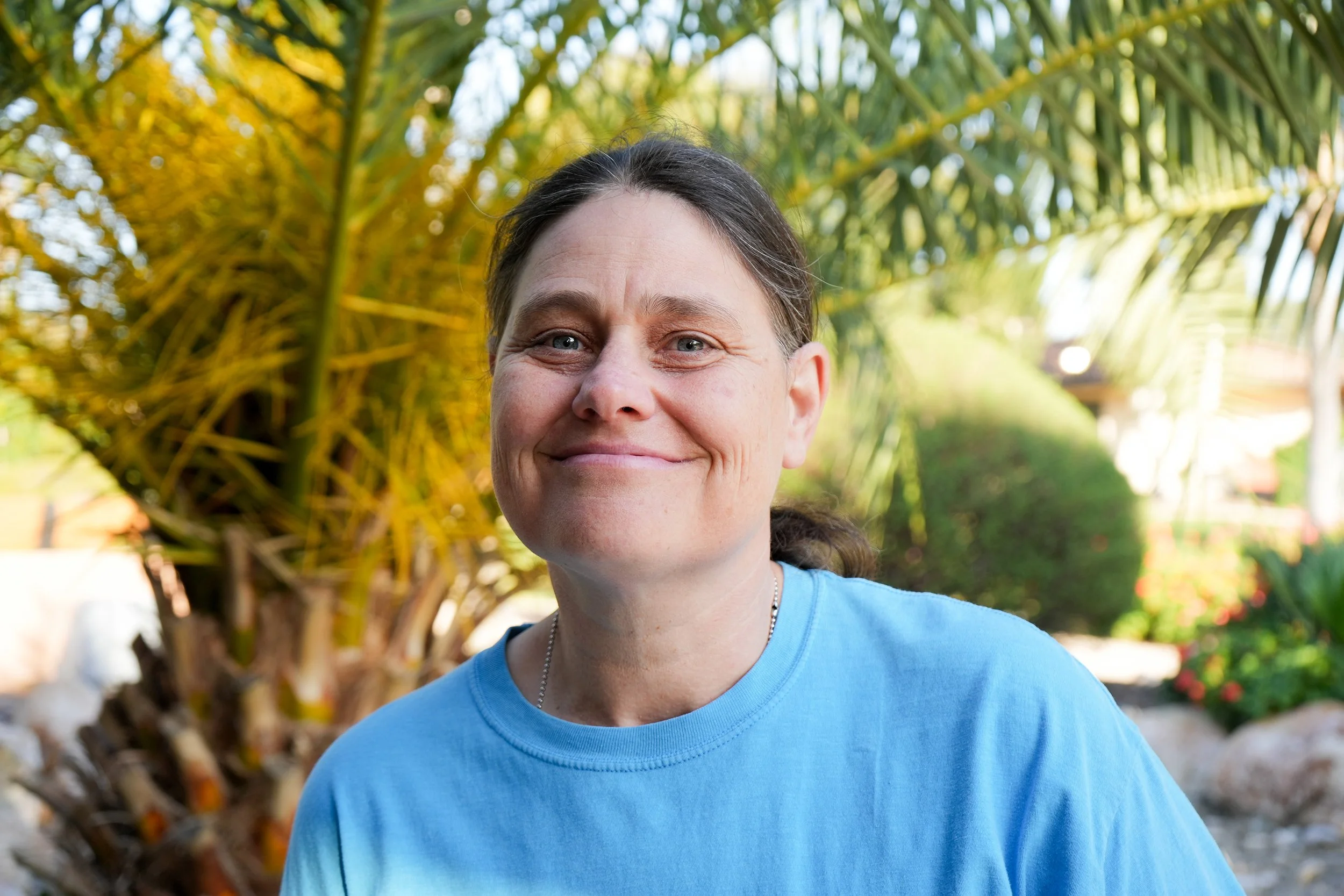 Woman in a blue tshirt poses for headshot