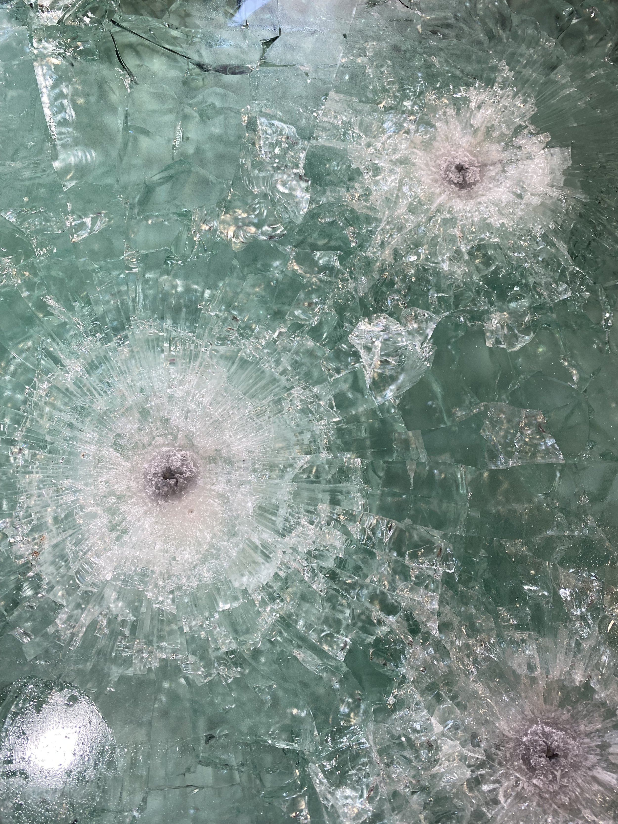 Tested laminated ballistic glass demonstrating bullet-resistant protection and layered glazing construction