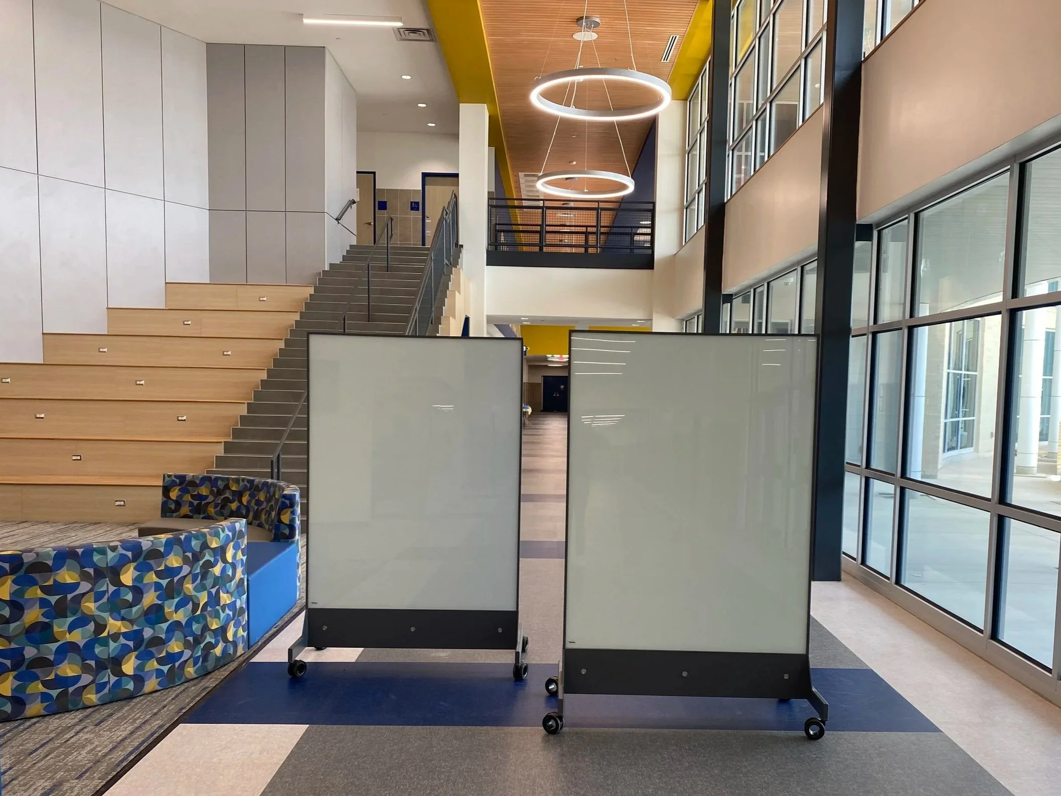 TAG Mobile bulletproof mobile whiteboards positioned in a modern school entry hallway for discreet ballistic protection.