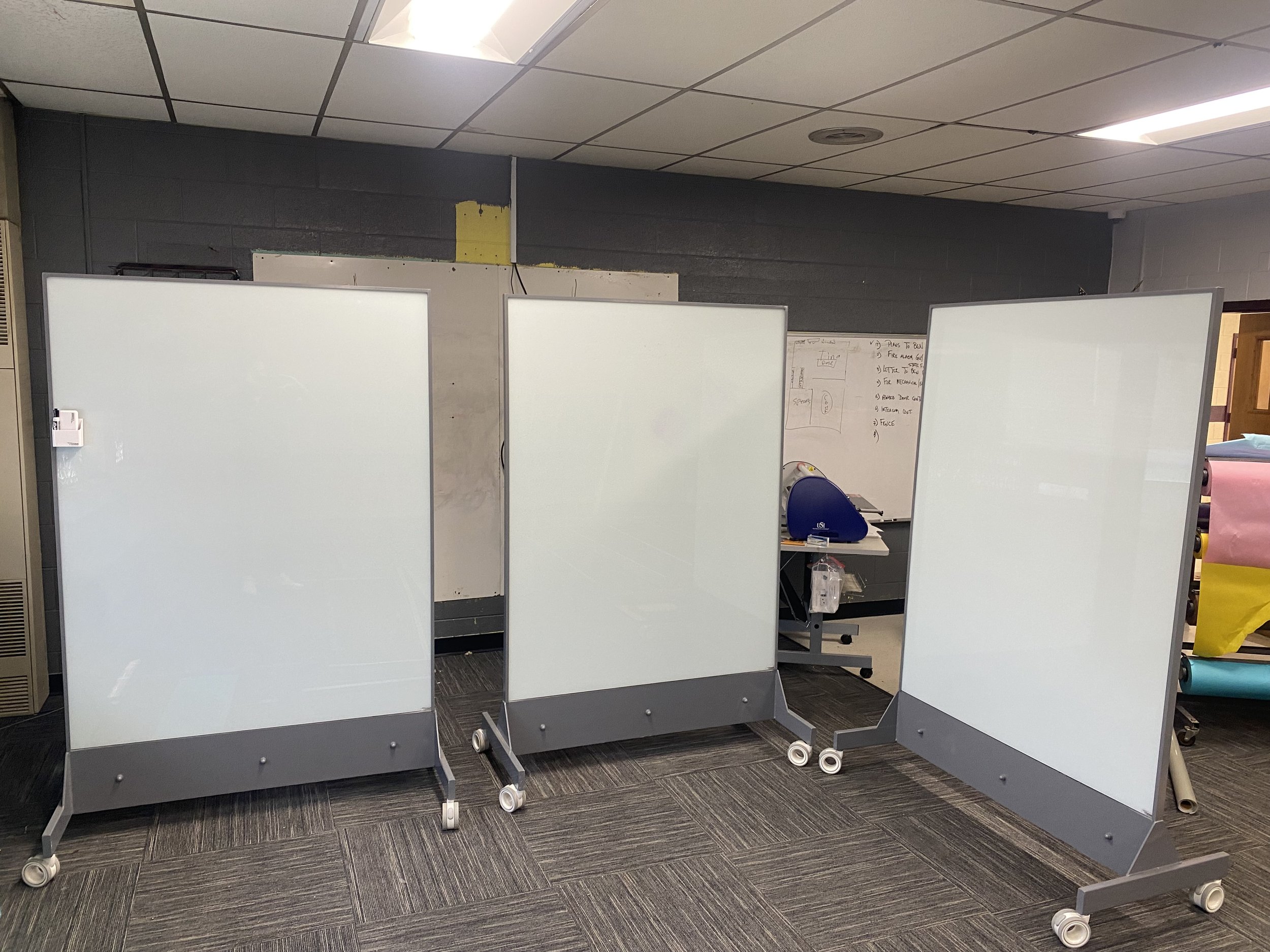 TAG Mobile bulletproof mobile whiteboard positioned inside classroom with writable glass surface for everyday learning and ballistic protection