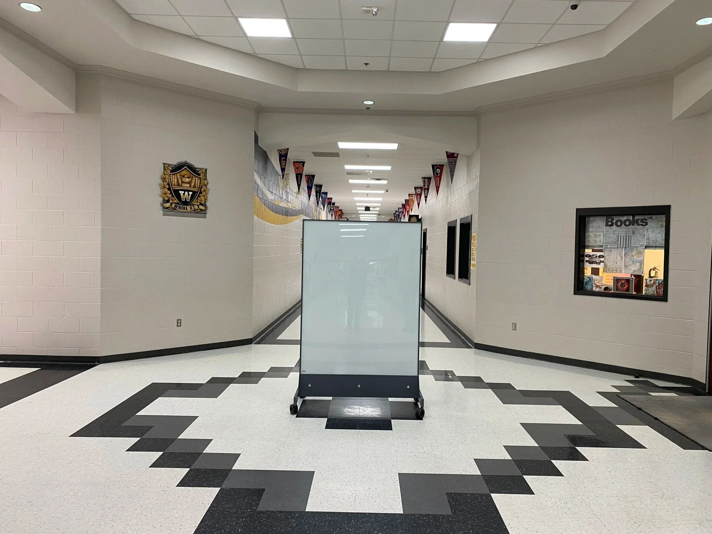 TAG Mobile ballistic whiteboard positioned in a school hallway providing mobile protection and everyday functionality.