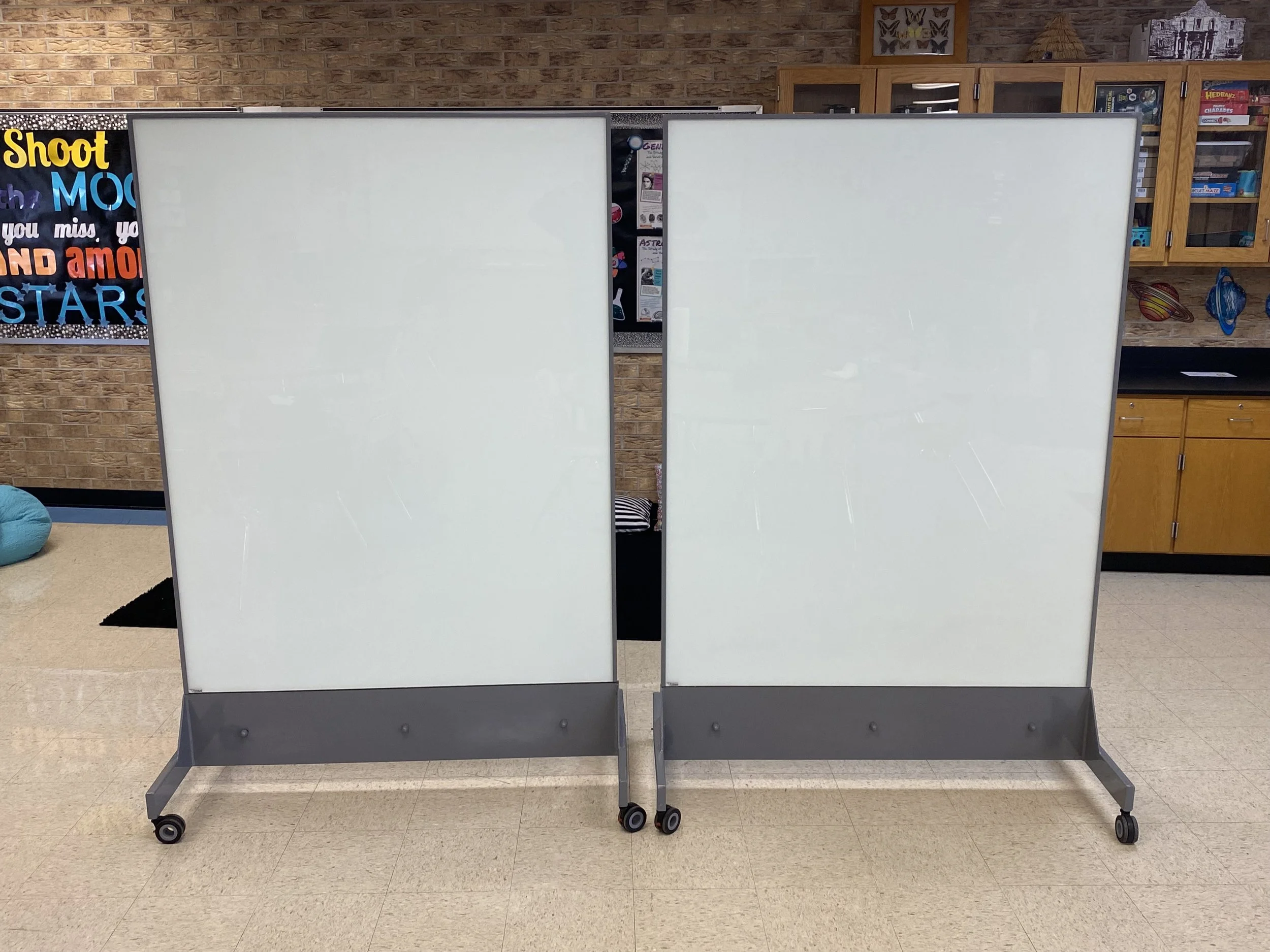 Two TAG Mobile bulletproof mobile whiteboards arranged side by side in a classroom to form a hard corner and demonstrate how multiple units provide added protection during lockdown or shelter-in-place scenarios.