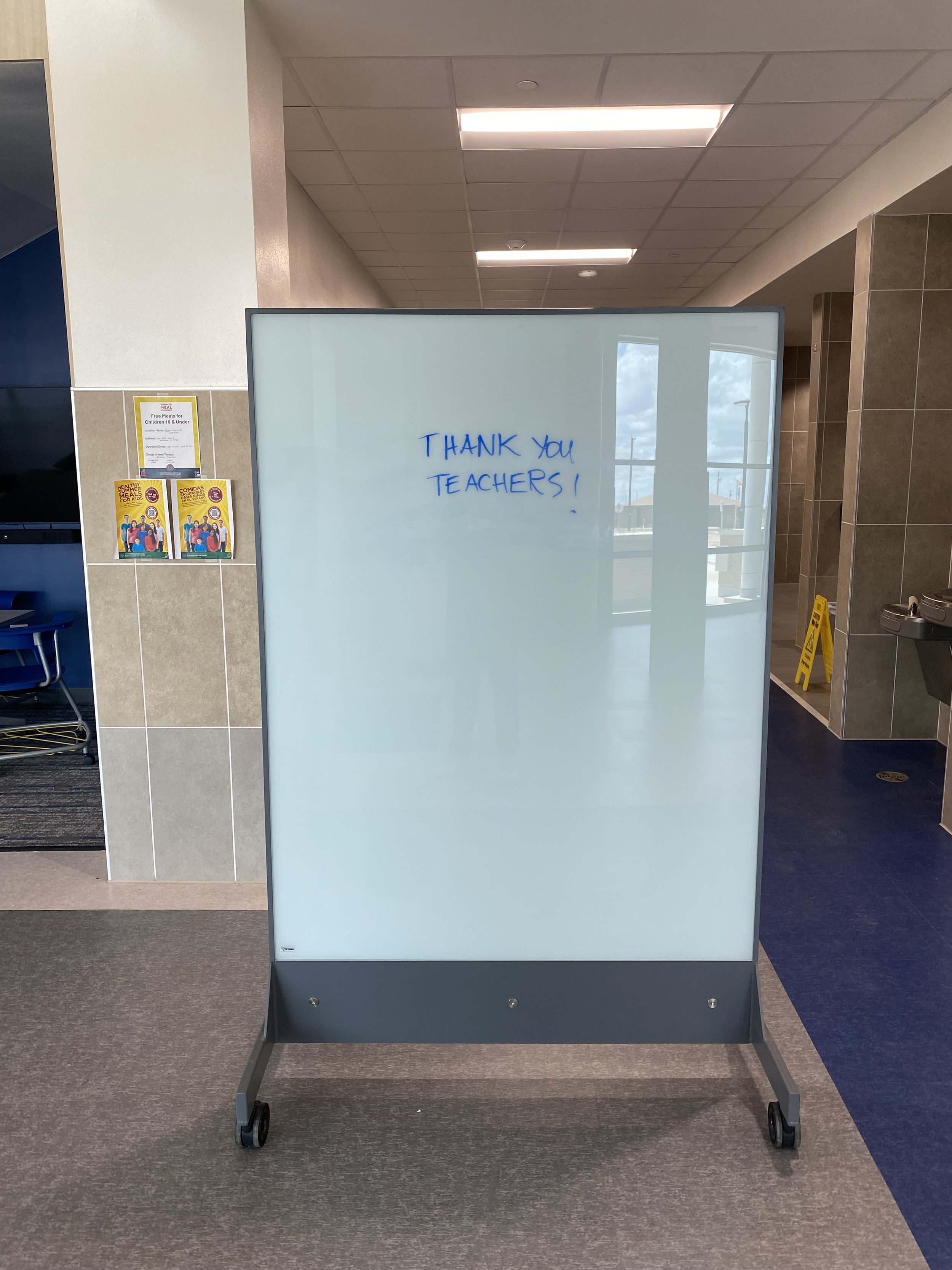 TAG Mobile bulletproof mobile whiteboard in a school hallway with a thank you teachers message written on the dry-erase surface.