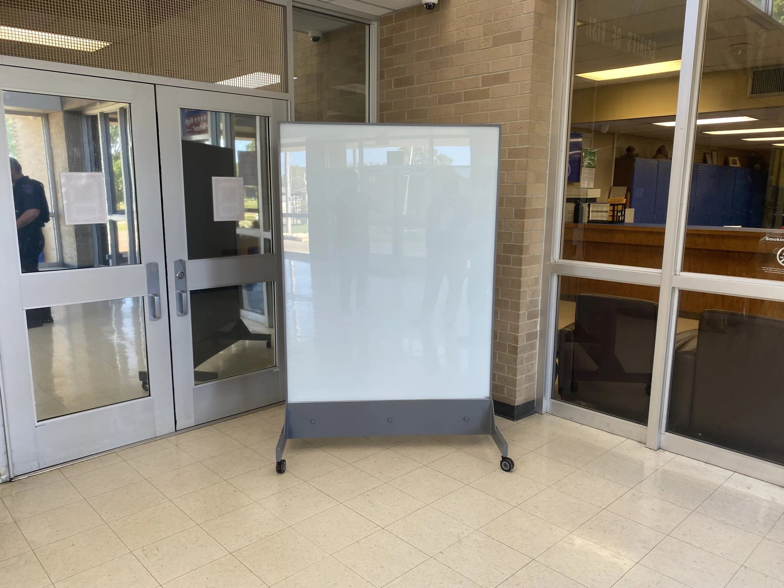 Multiple TAG Mobile bulletproof mobile whiteboards positioned throughout school entryway for layered ballistic protection