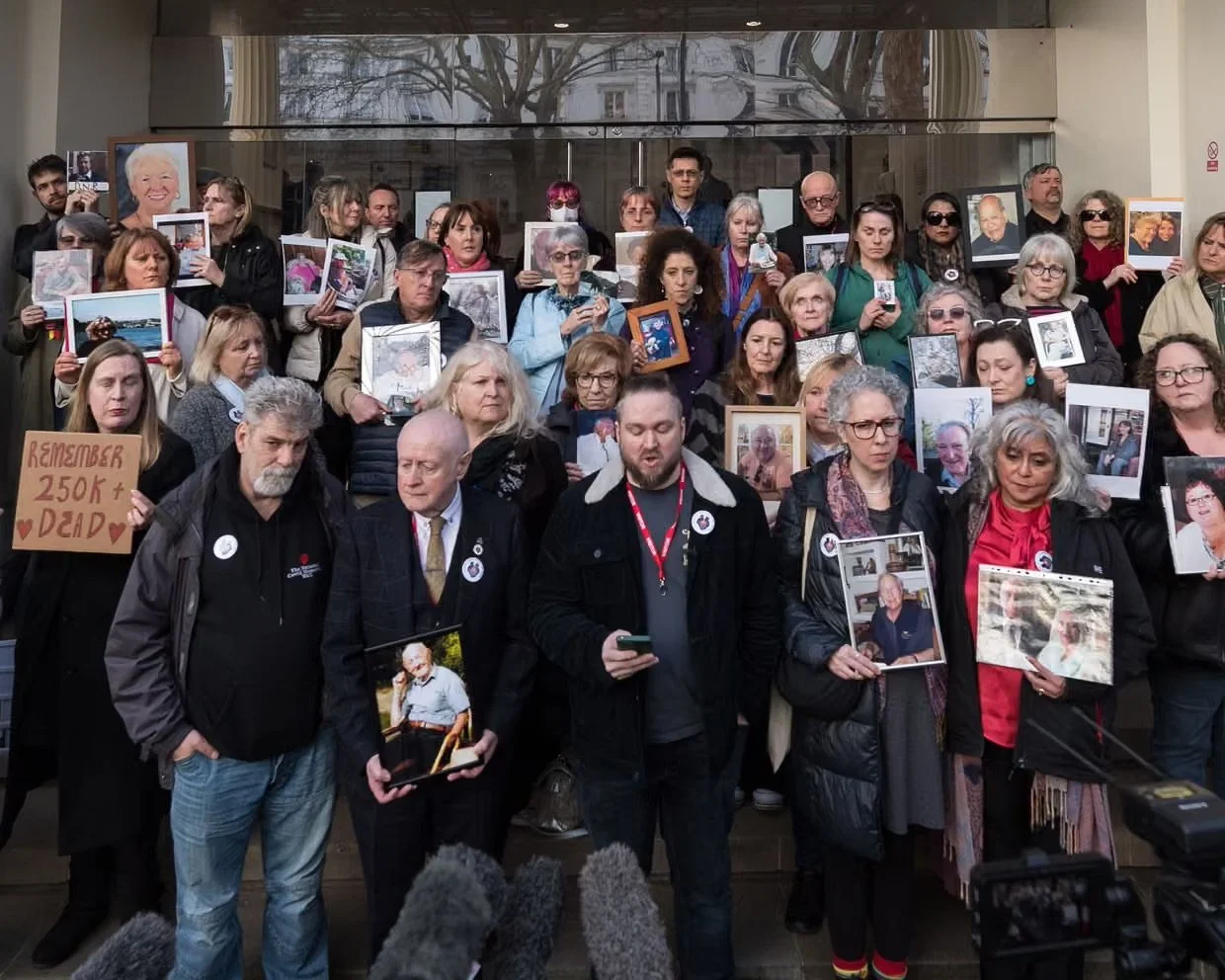 Bereaved campaigners outside the Covid Inquiry holding photographs of their loved ones