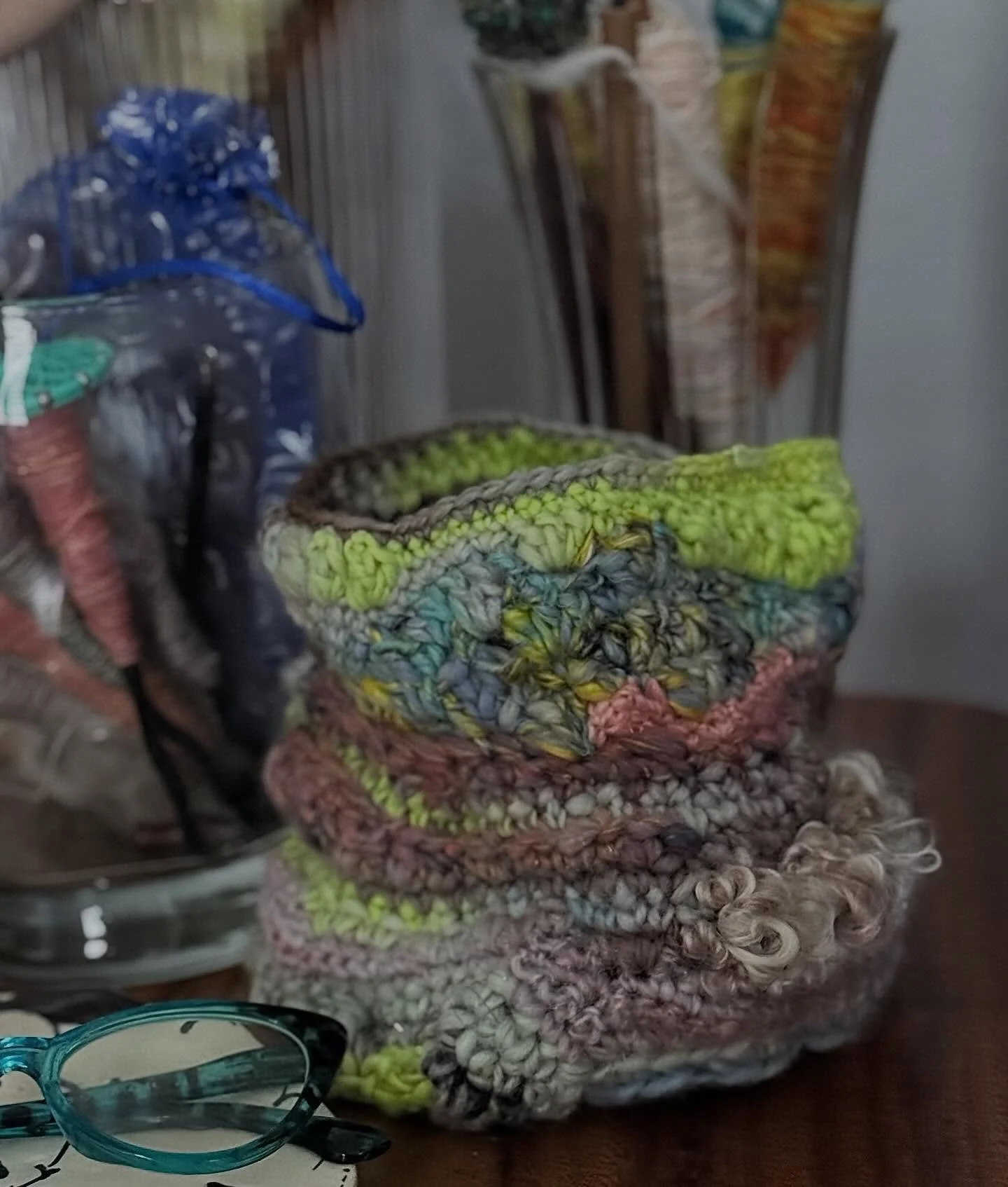 I adore making freeform vessels with hand spun yarn. The texture and surprising shapes are always a feast for the senses. This one holds is small crochet project. The contrast of this little piece of beauty next to the glass jars and wooden table is 