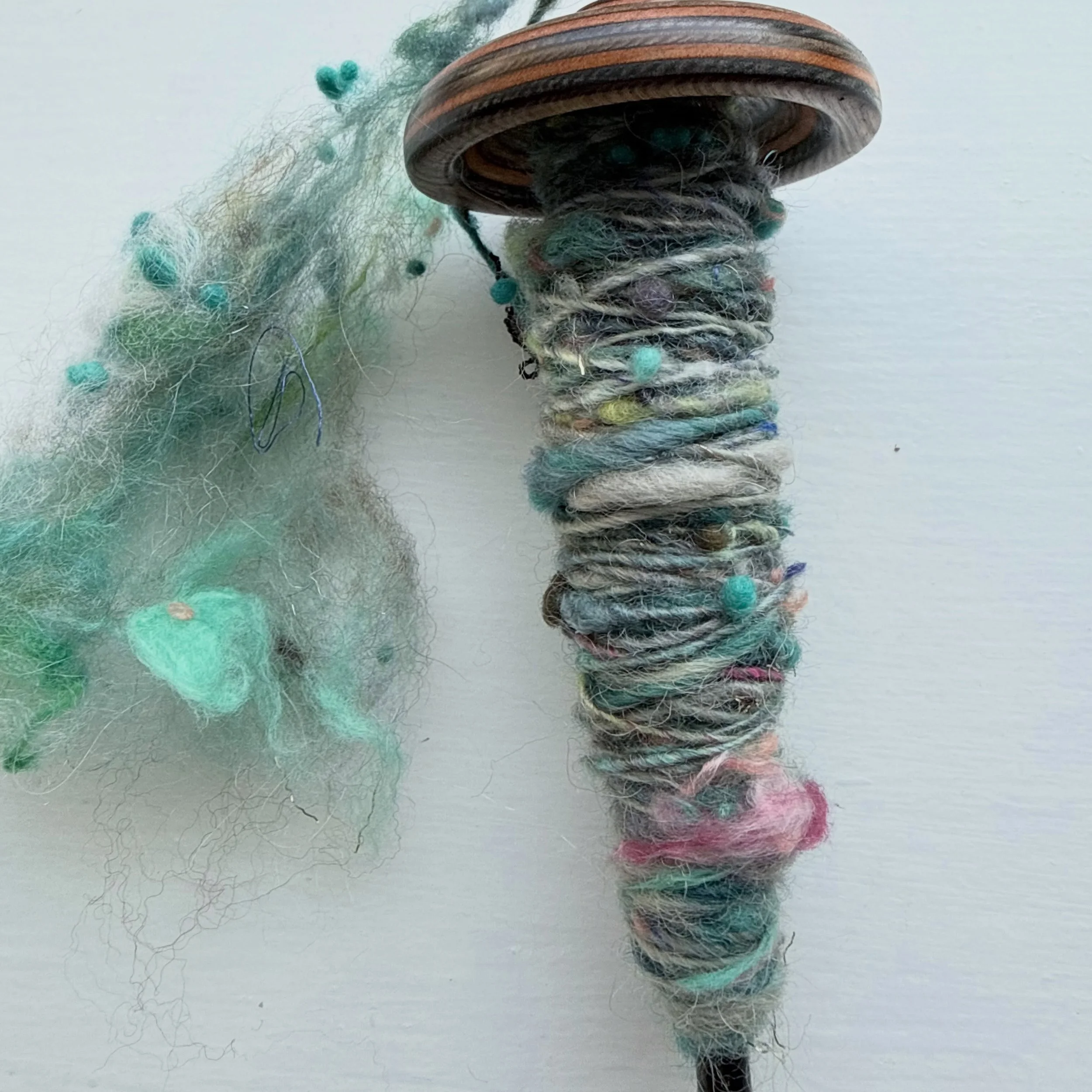 I just had to stop and share this beautiful spin. This is a wild art batt that I am spinning super thing on my spindle. My plan was to ply it with a single in the light gray that flows through the batt. But then I thought, why not use it as a carry a