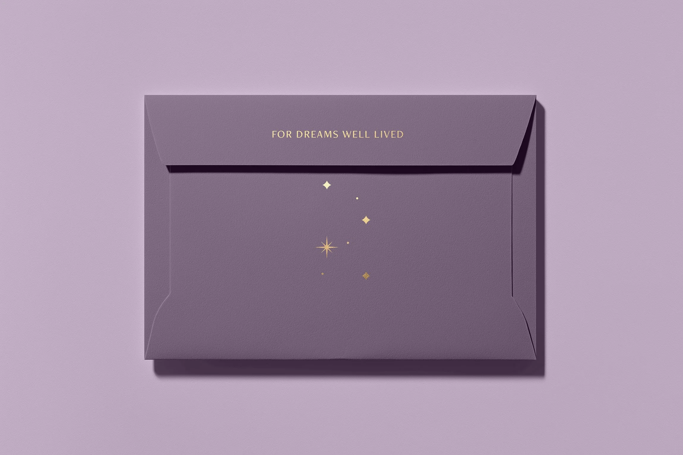 Lavender envelope featuring the Reverie Residential tagline “For Dreams Well Lived” with gold constellation accents.
