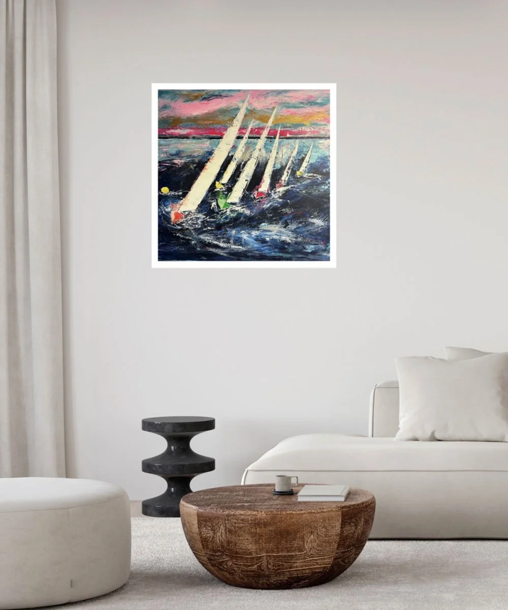 A modern living room with a white sofa, a wooden coffee table, a black side table, and a colorful abstract painting of sailboats on the wall.