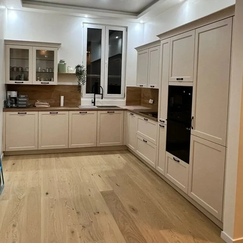 Kitchen with beige cabinets, wooden countertops, a window above the sink, and light-colored wood flooring.