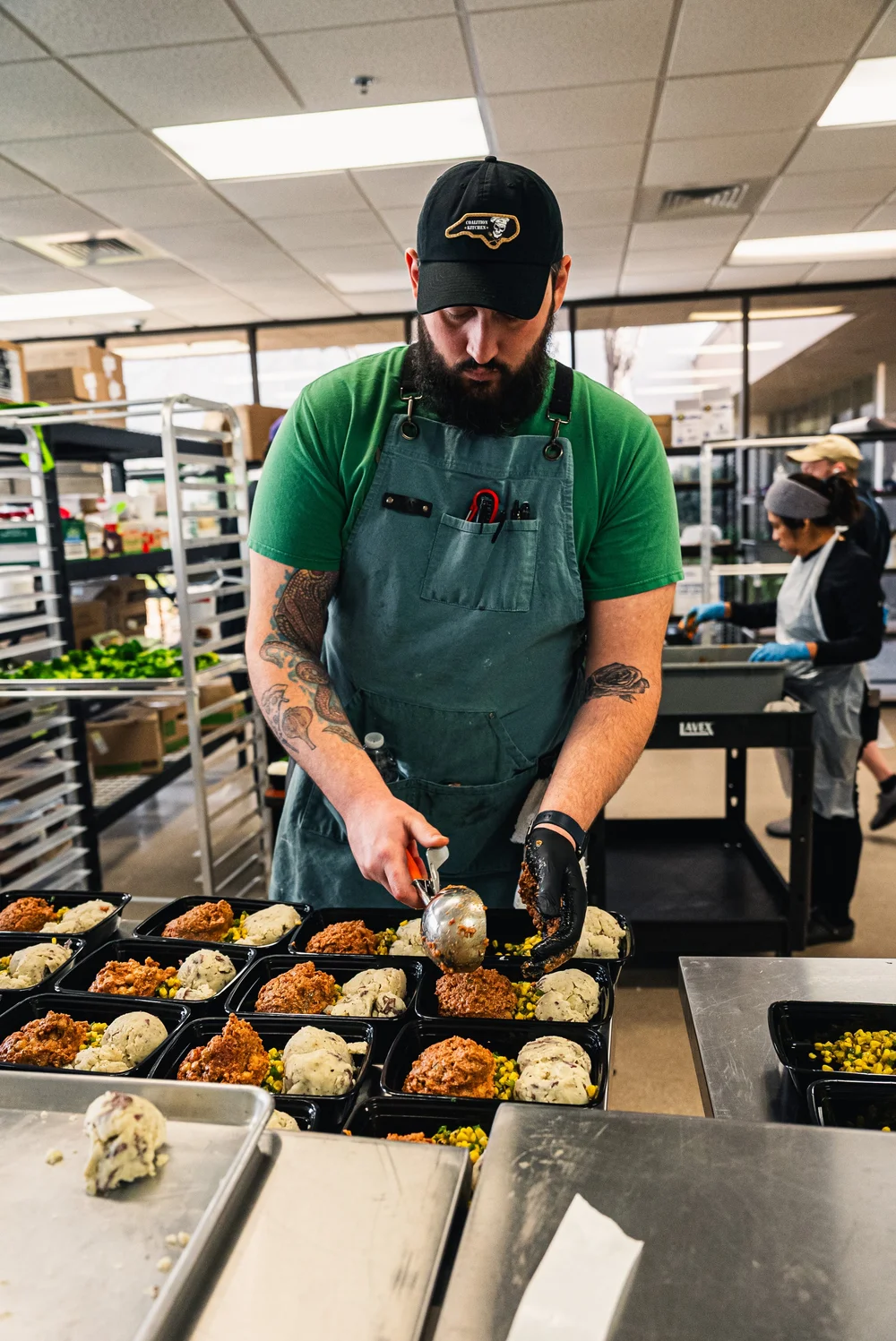 Coalition Kitchen team portioning freshly prepared meals in the Raleigh kitchen