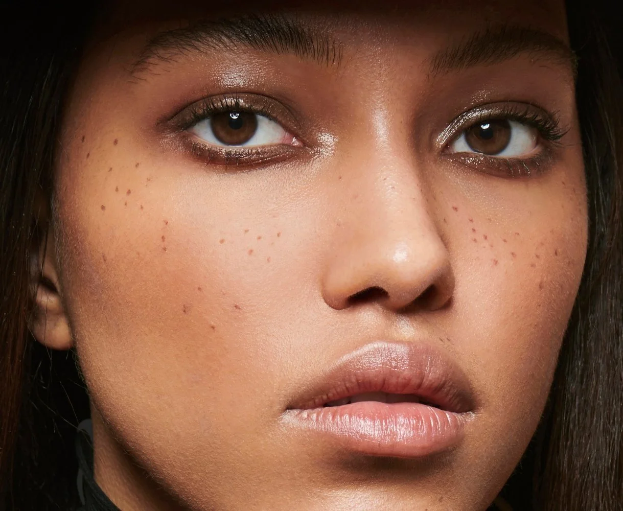Extreme close-up of a model's eye with radiant, dewy skin and a subtle copper shimmer, illustrating the Glow-Up look from The Beauty Confidante Clean Beauty Masterclass