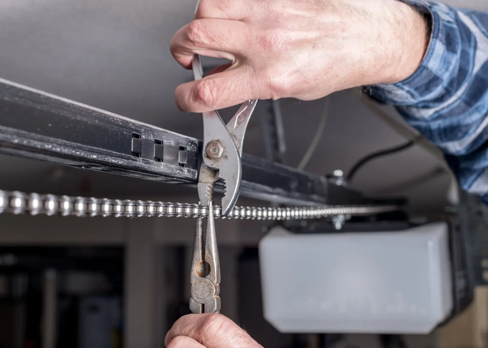 Local garage door maintenance service inspecting springs, tracks, and hardware by Reyes Garage Door LLC
