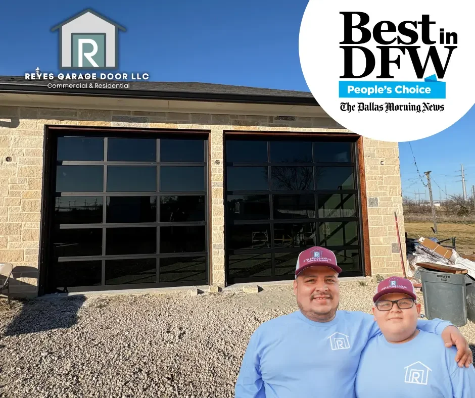 Two men wearing blue shirts and maroon caps standing in front of a new garage door installation at a commercial or residential building, with a certificate of recognition from Best in DFW and the Dallas Morning News displayed in the top right corner.