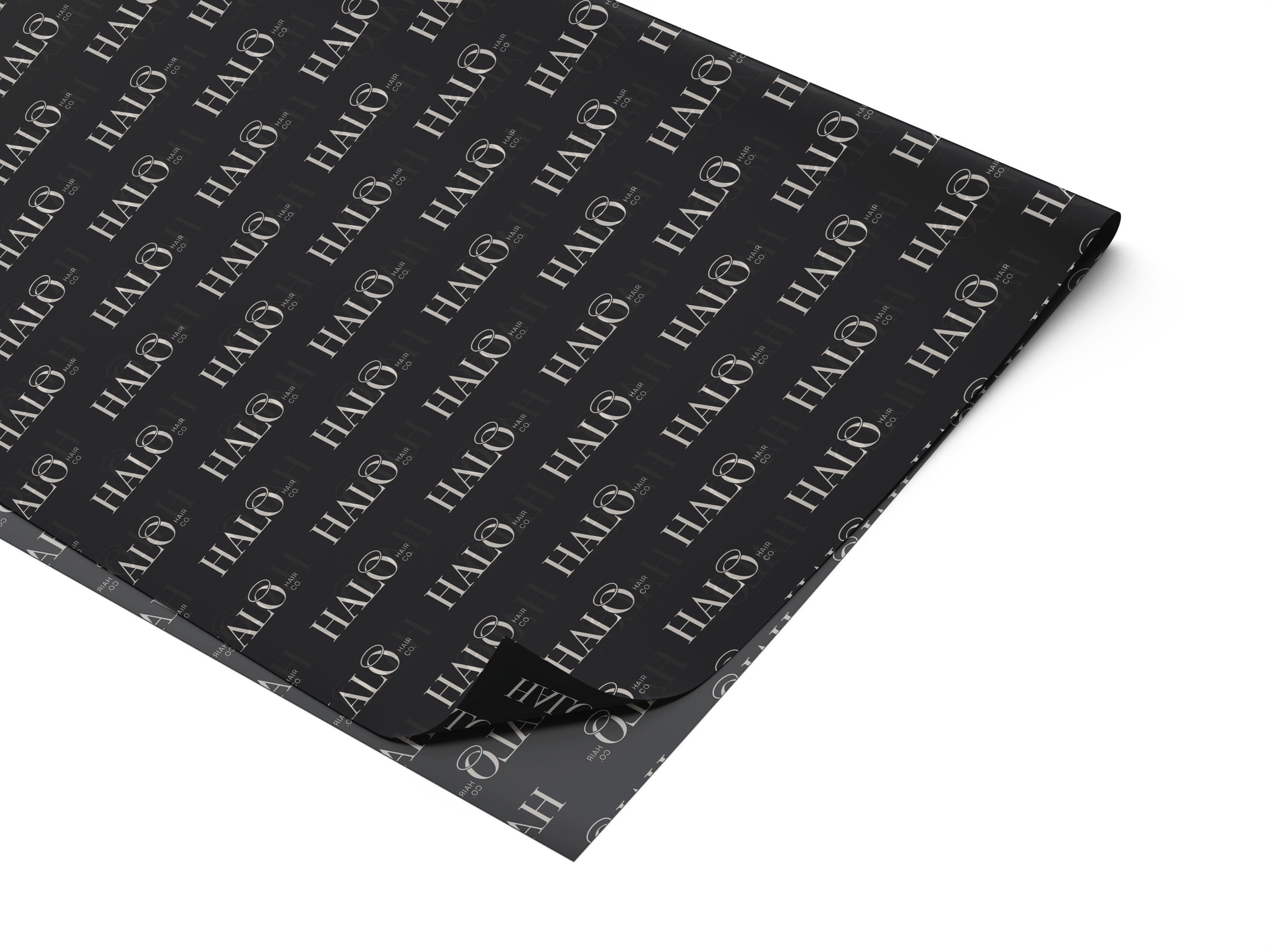 Black wrapping paper with white 'HALO' and ring logo pattern