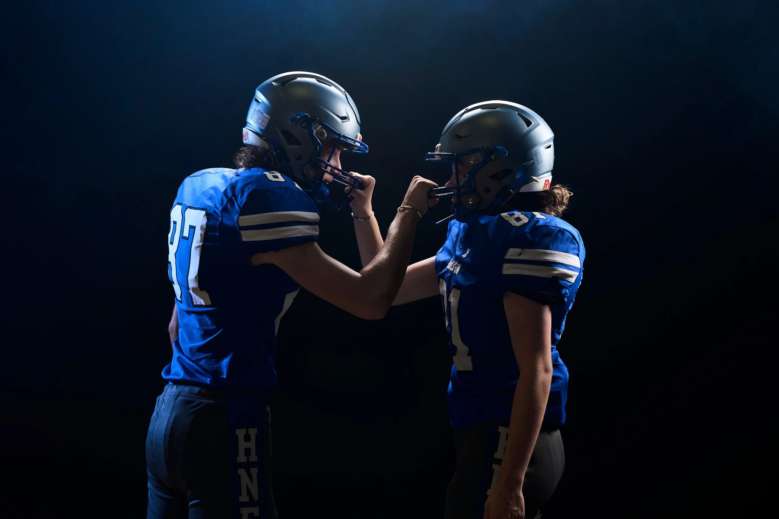 Two Holton High School football teammates in blue jerseys facing each other during a Still and Wild media day session in Holton, Kansas.