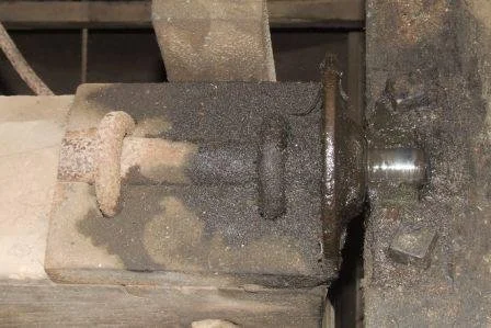 Close-up of a rusty metal vice mounted on a workbench.