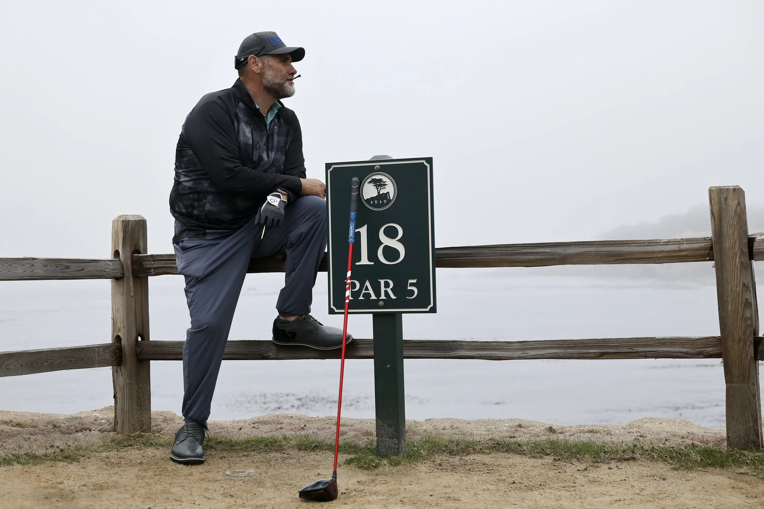 A man recreates the iconic photo of Jack Nicklaus sitting on the 18th hole of Pebble Beach Golf Links