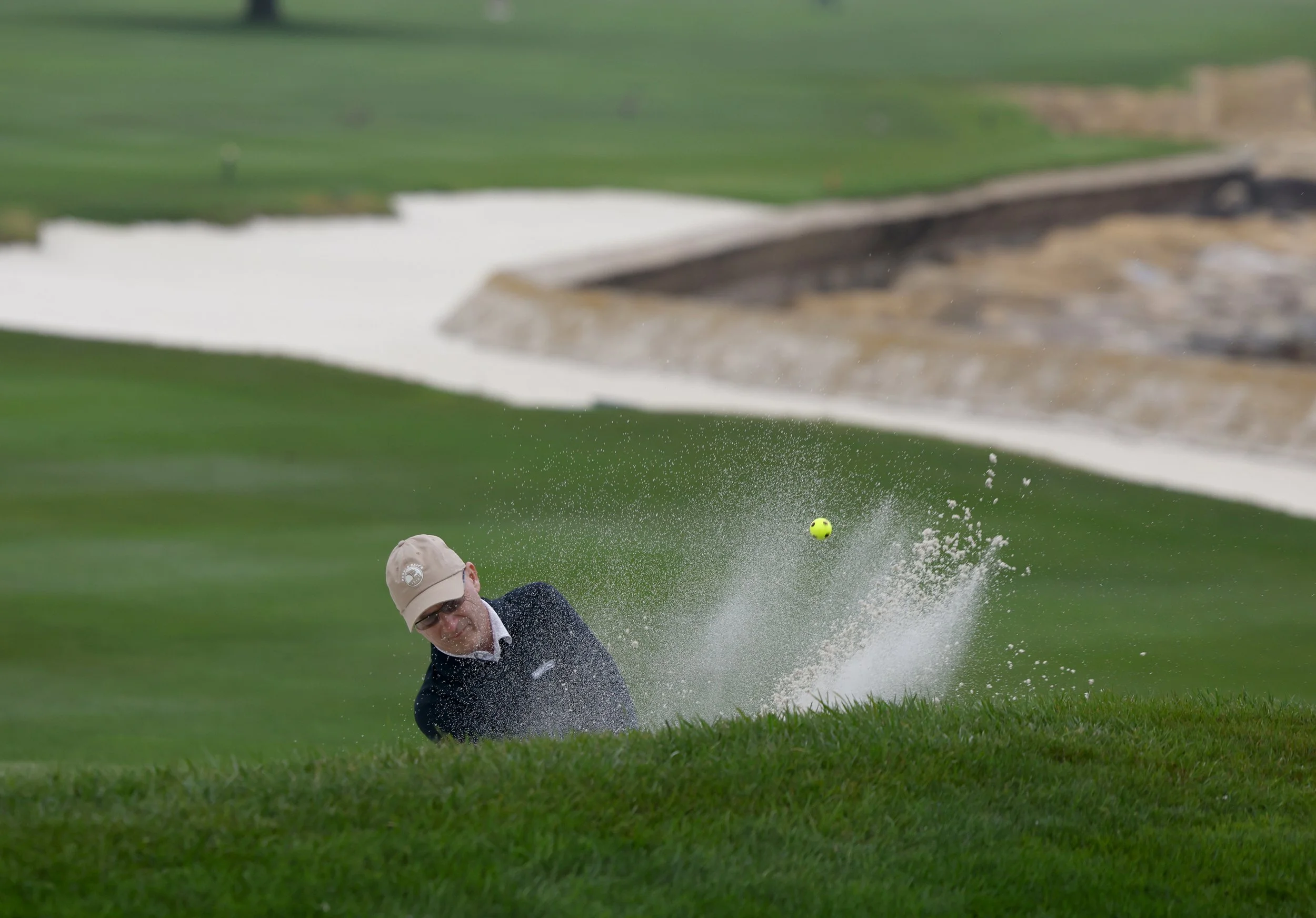 A golfer hits the ball from the sand trap at Pebble Beach Golf Links