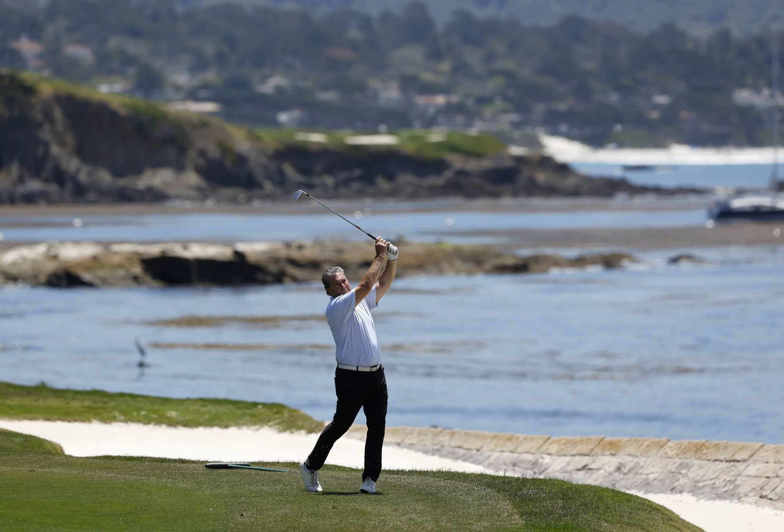 A golfer hits the ball on the 18th hole at Pebble Beach Golf Links