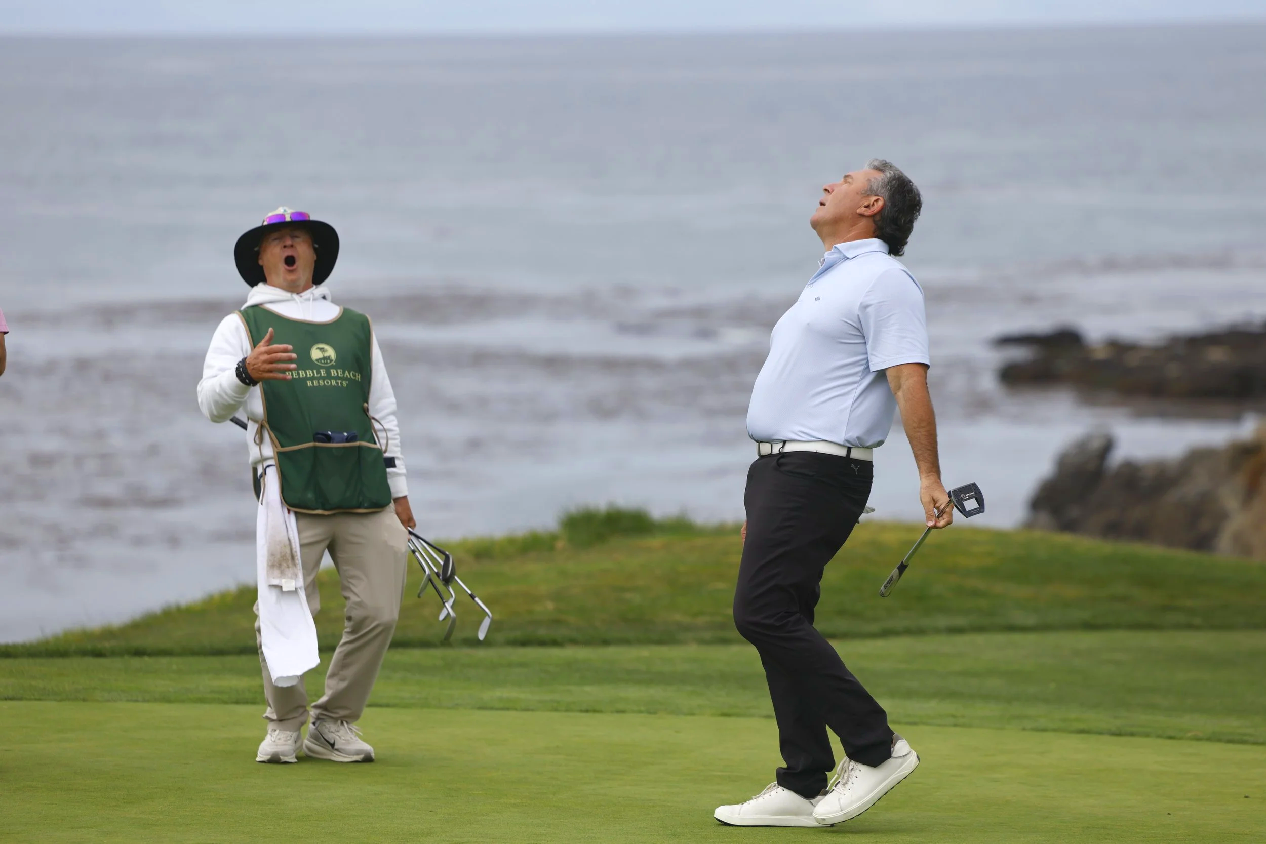 A golfer and a caddie react after a missed putt on the 6th hole at Pebble Beach Golf Links