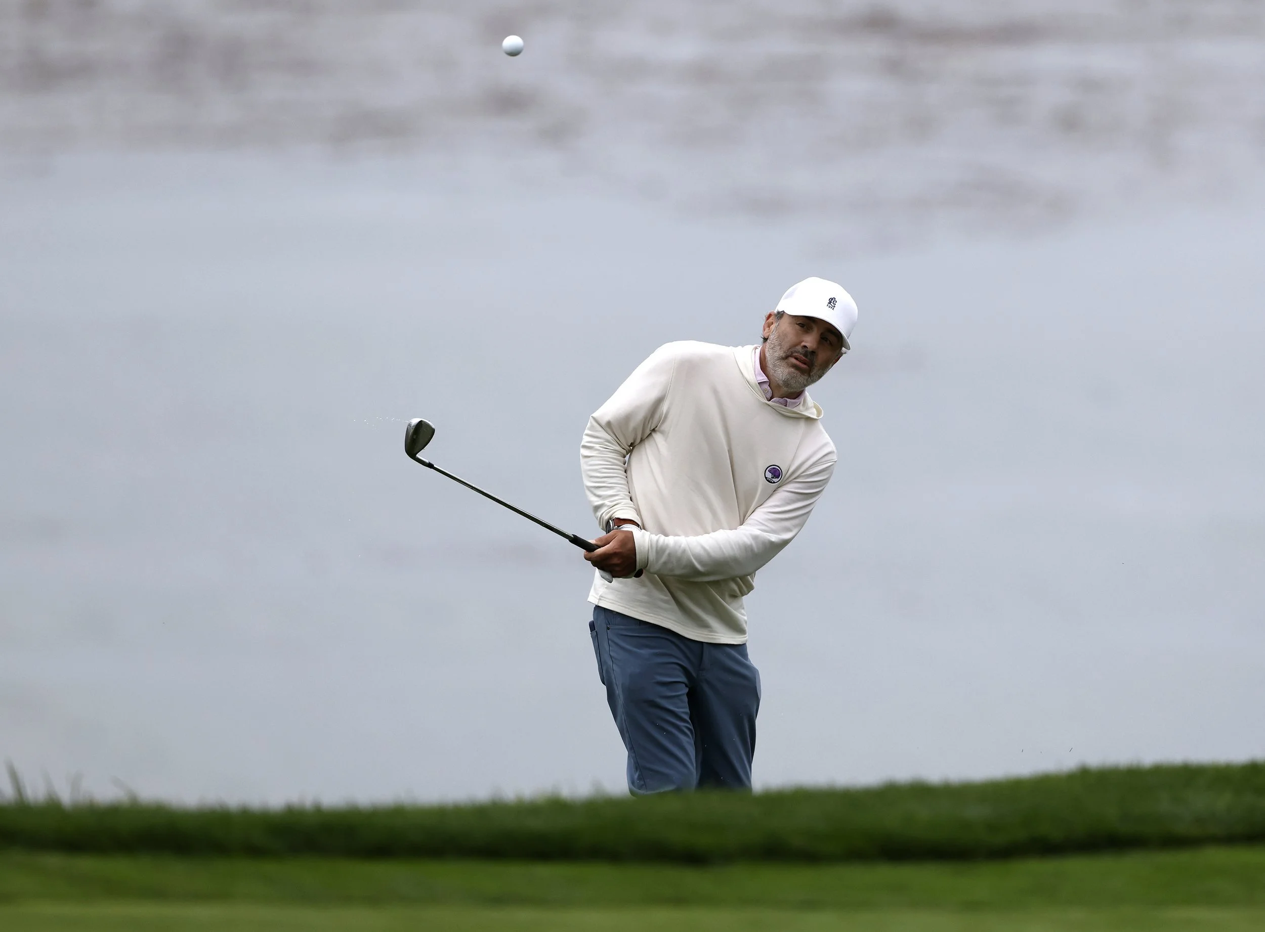 A golfer hits the ball from a sand trap on the 7th hole at Pebble Beach Golf Links