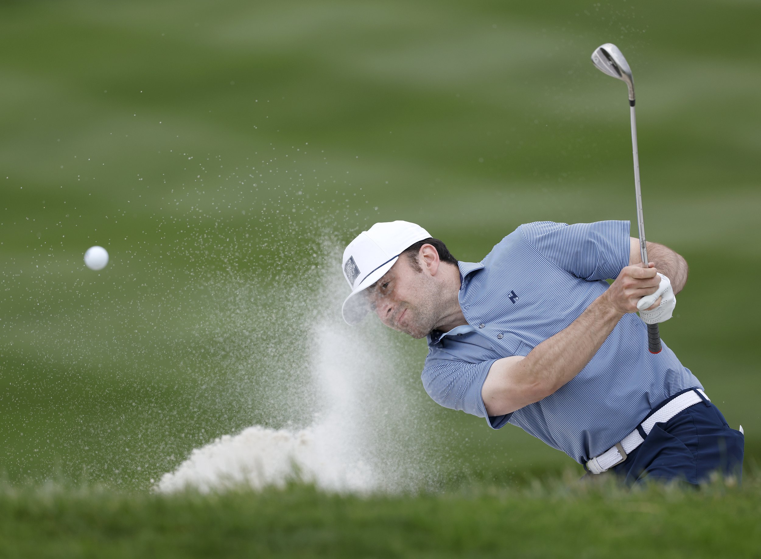 A golfer hit the ball out of a sand trap at Pebble Beach Golf Links