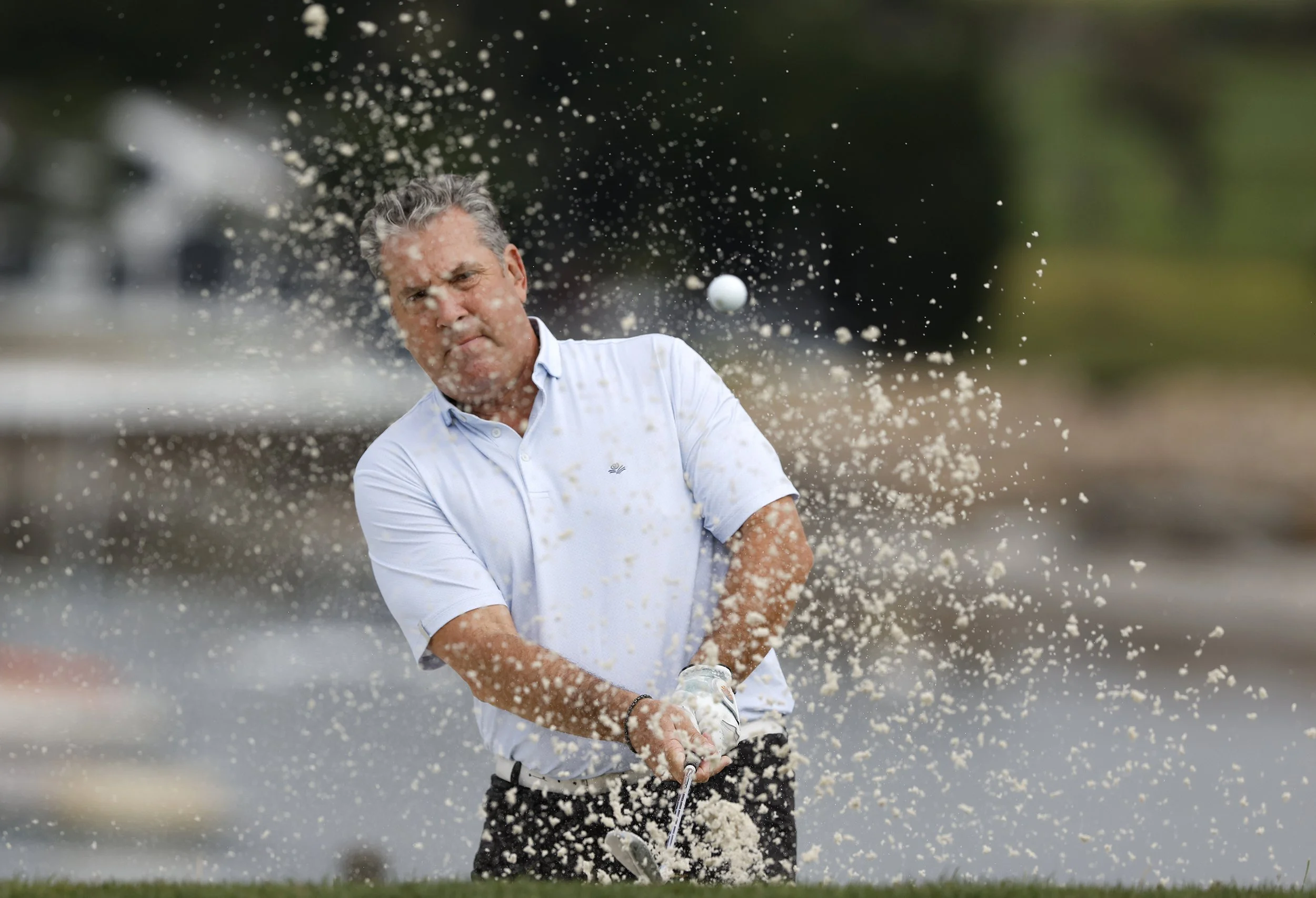 A golfer hits the ball out of a sand trap on the 6th hole at Pebble Beach Golf Links