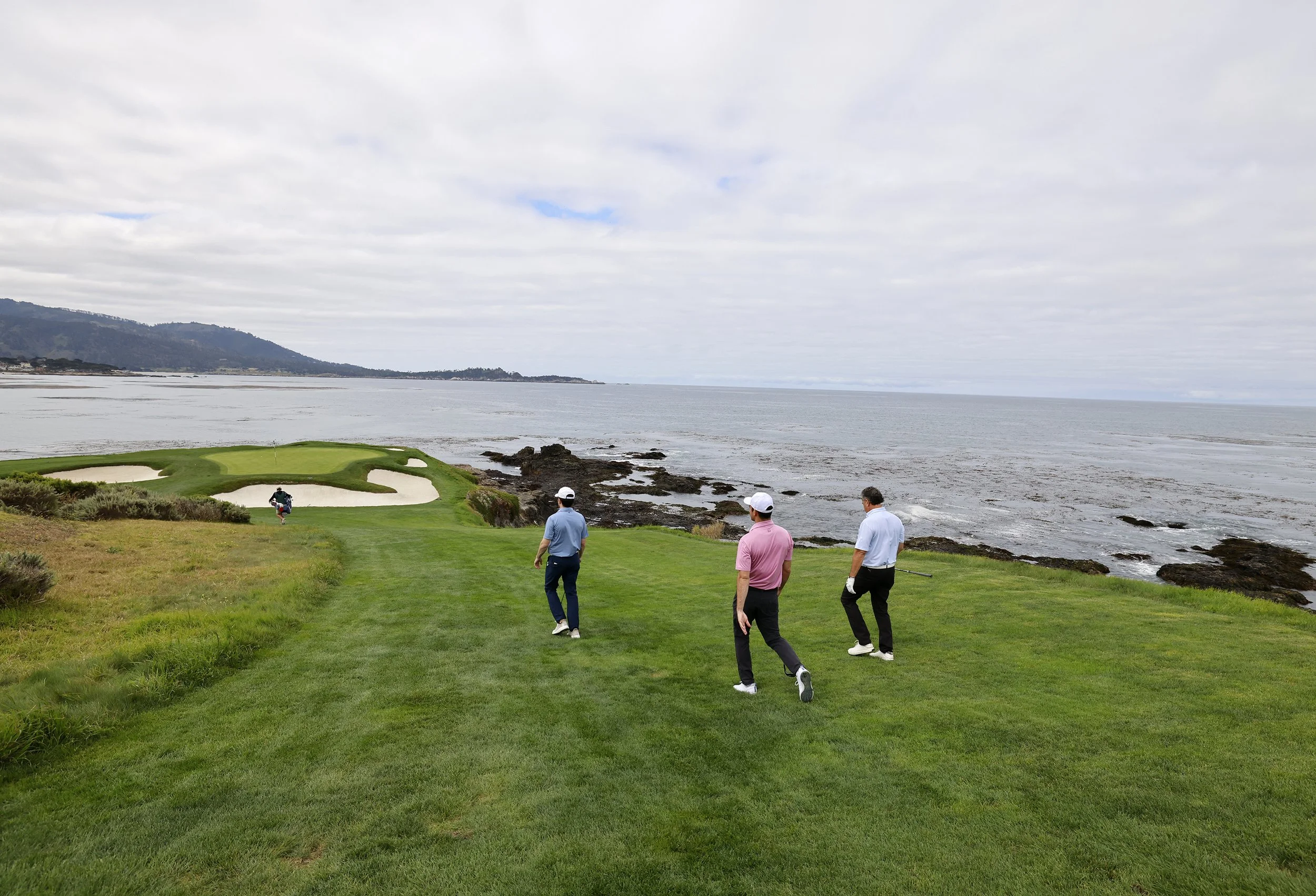 A group of golfer walk dow the fairway on the world famouse 7th hole at Pebble Beach Golf Links