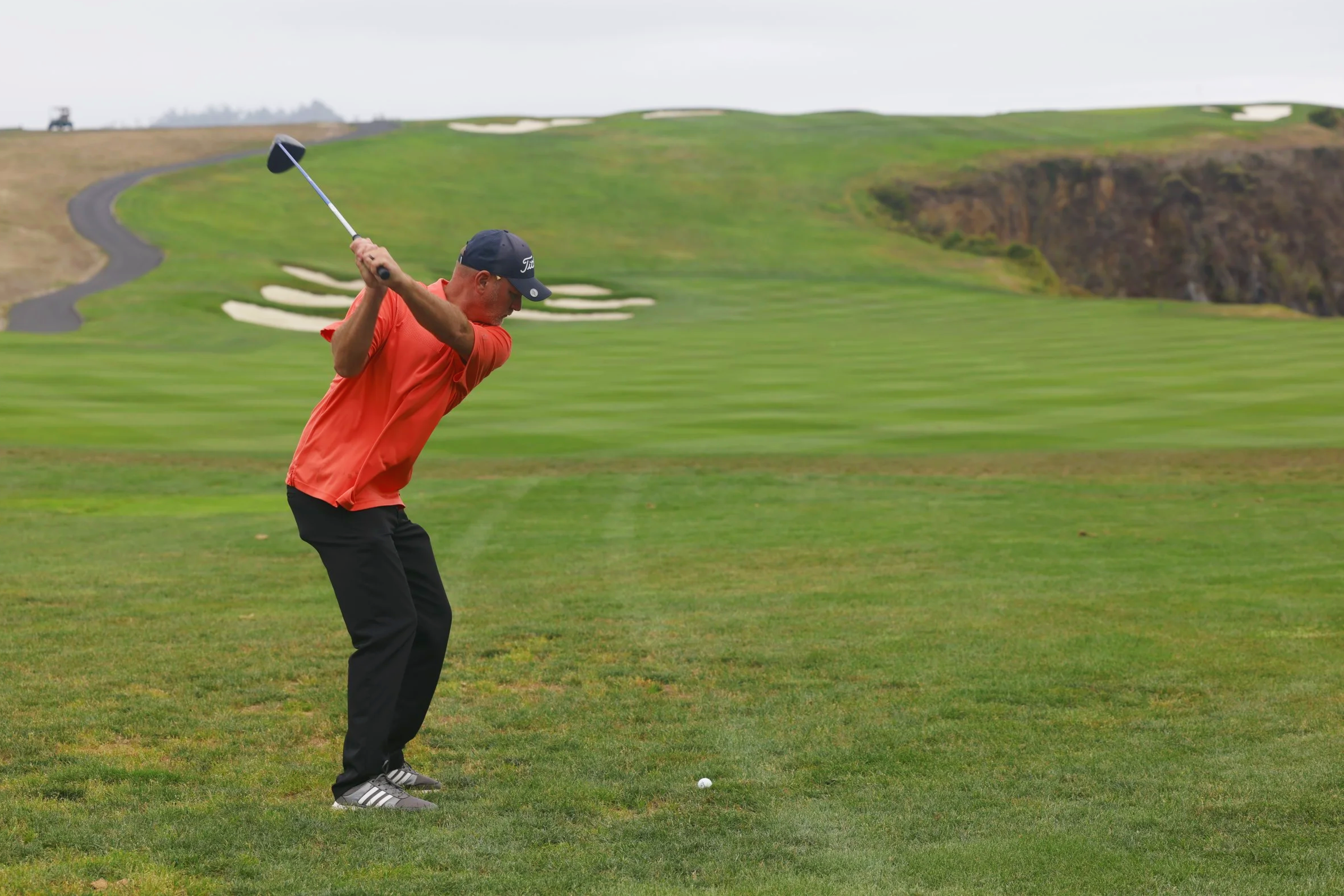 A golfer hits the ball from the fairway at Pebble Beach Golf Links