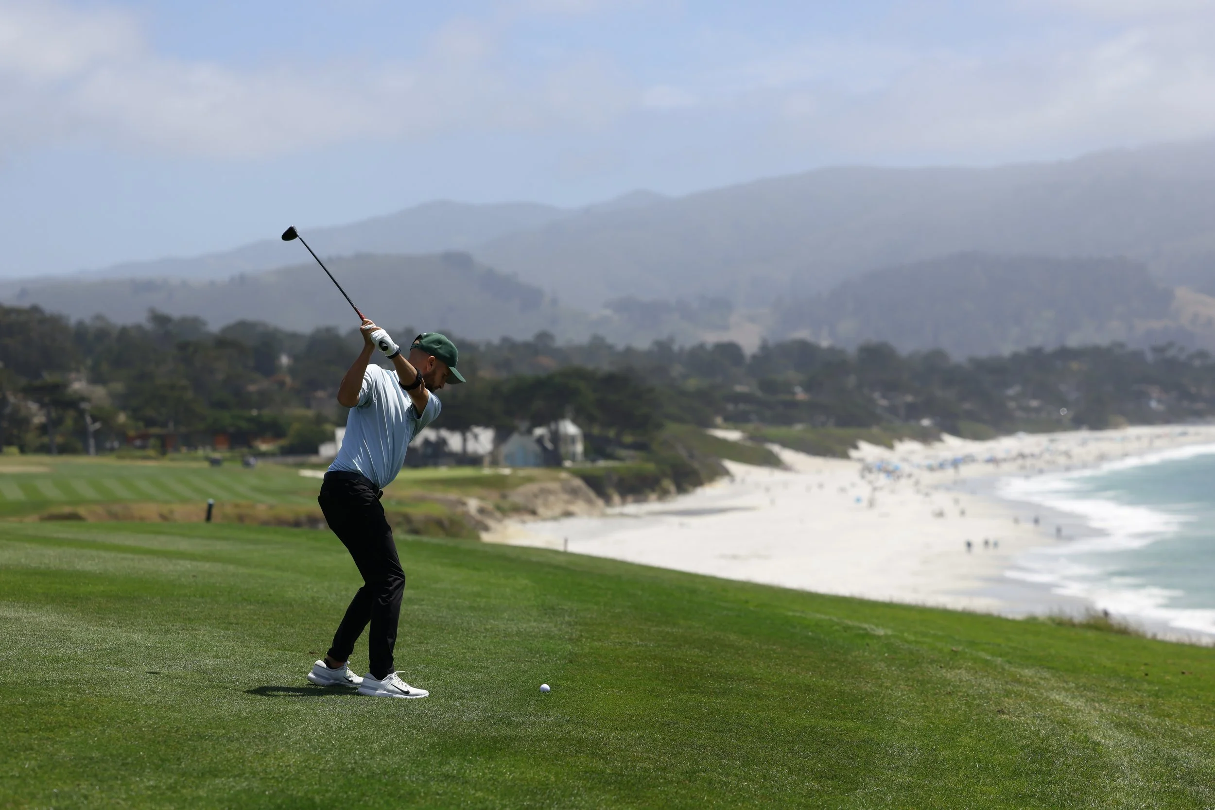 A golfer hits the ball from the fairway at Pebble Beach Golf Links