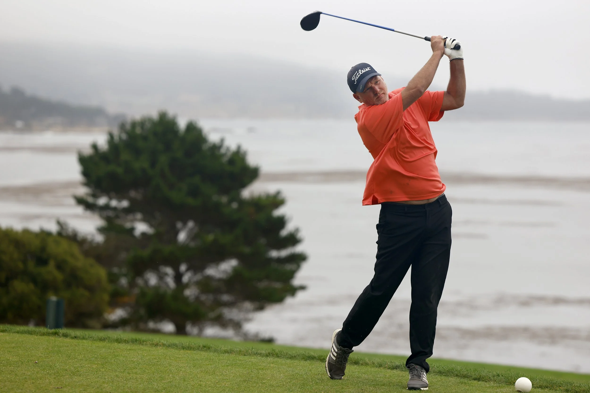 A golfer tees off at Peable Beach Golf Links