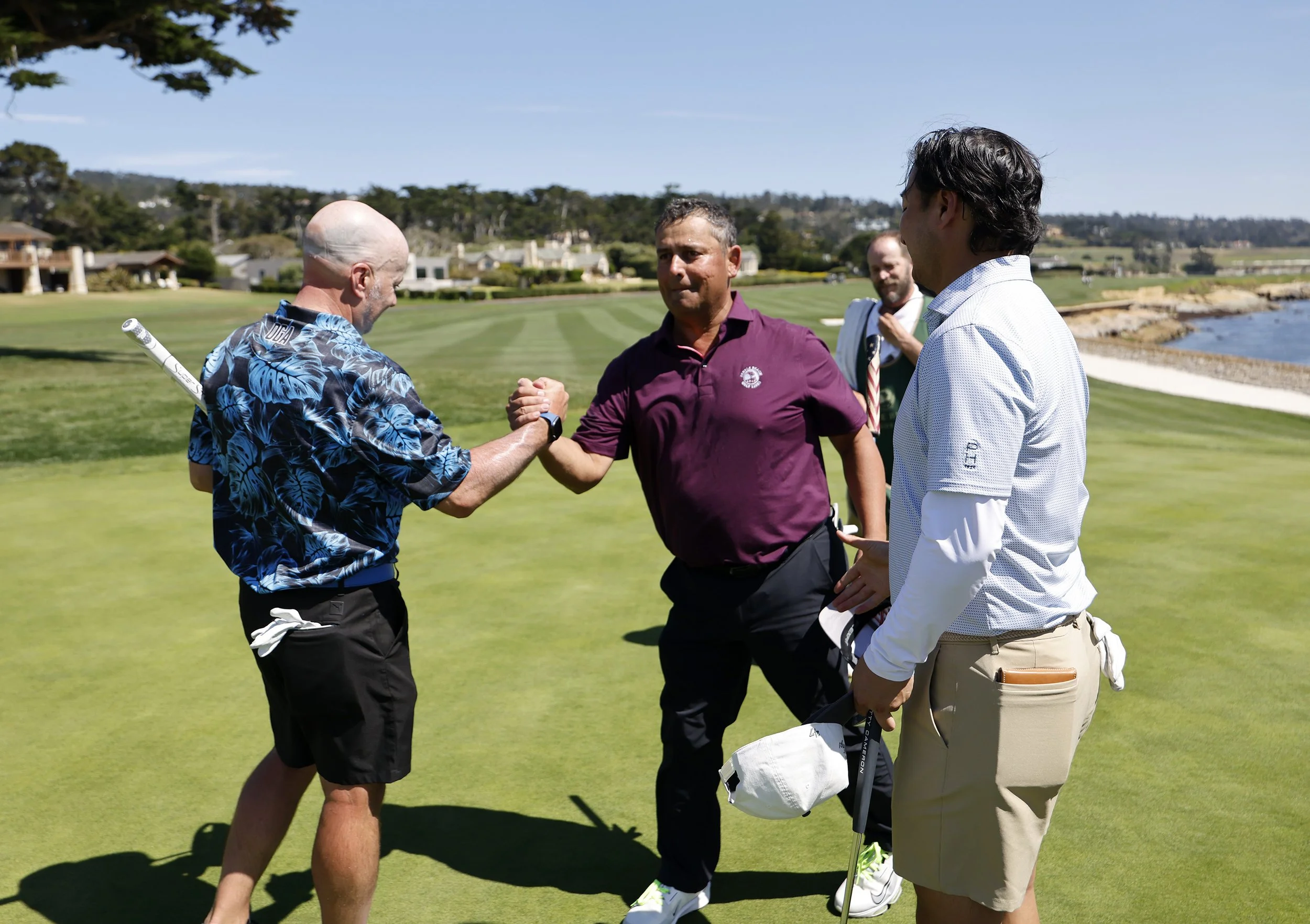 A group of golfers celebrate completing a round at Pebble Beach Golf Links