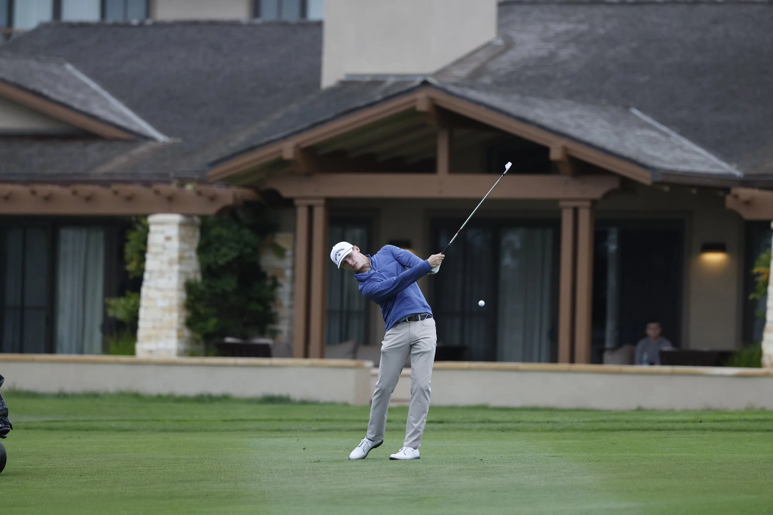 A golfer hots the ball from the fairway on the first hole at Pebble Beach Golf Links